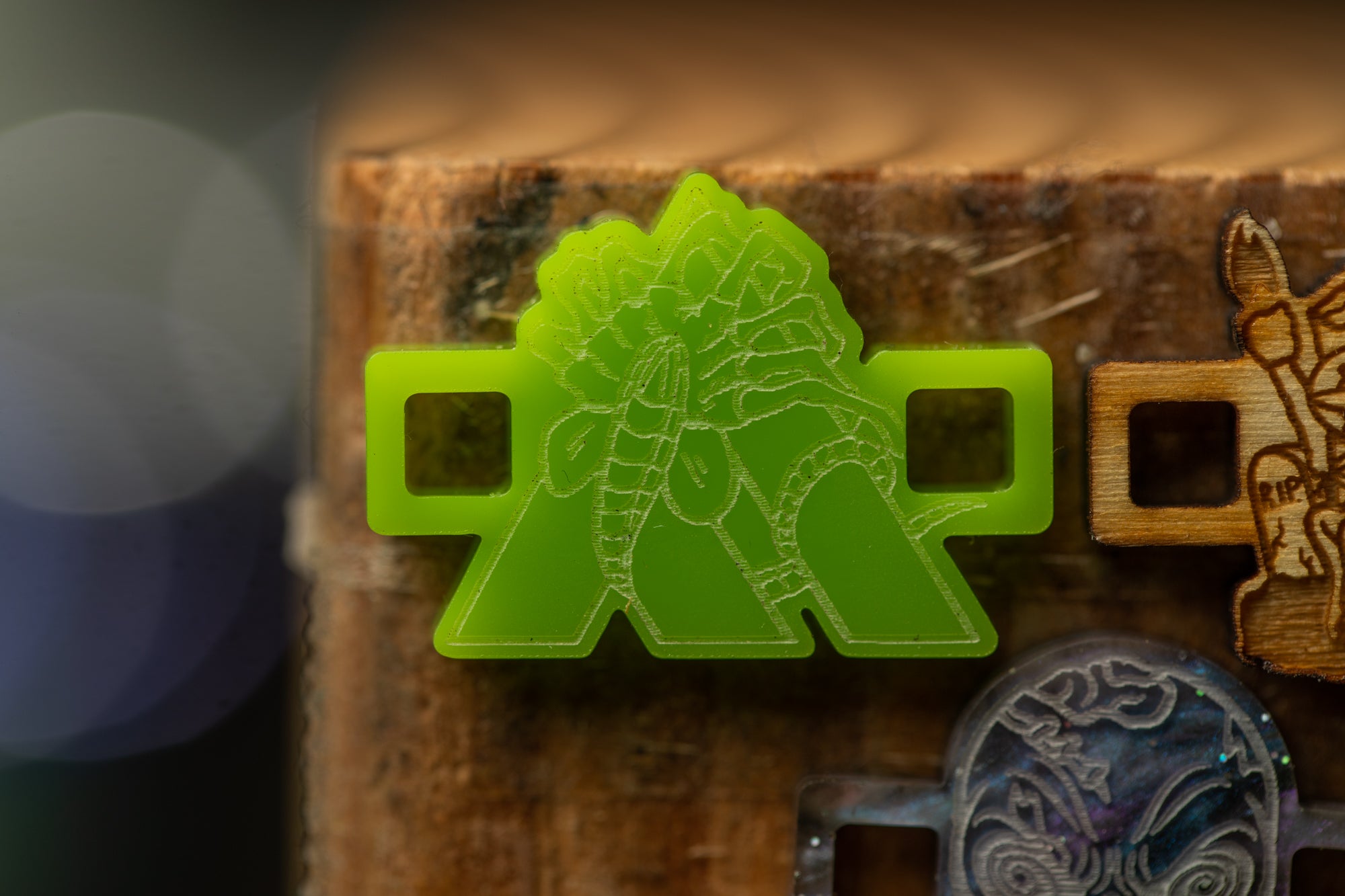 a close-up view of a green plastic object with a detailed design, placed on a wooden surface.