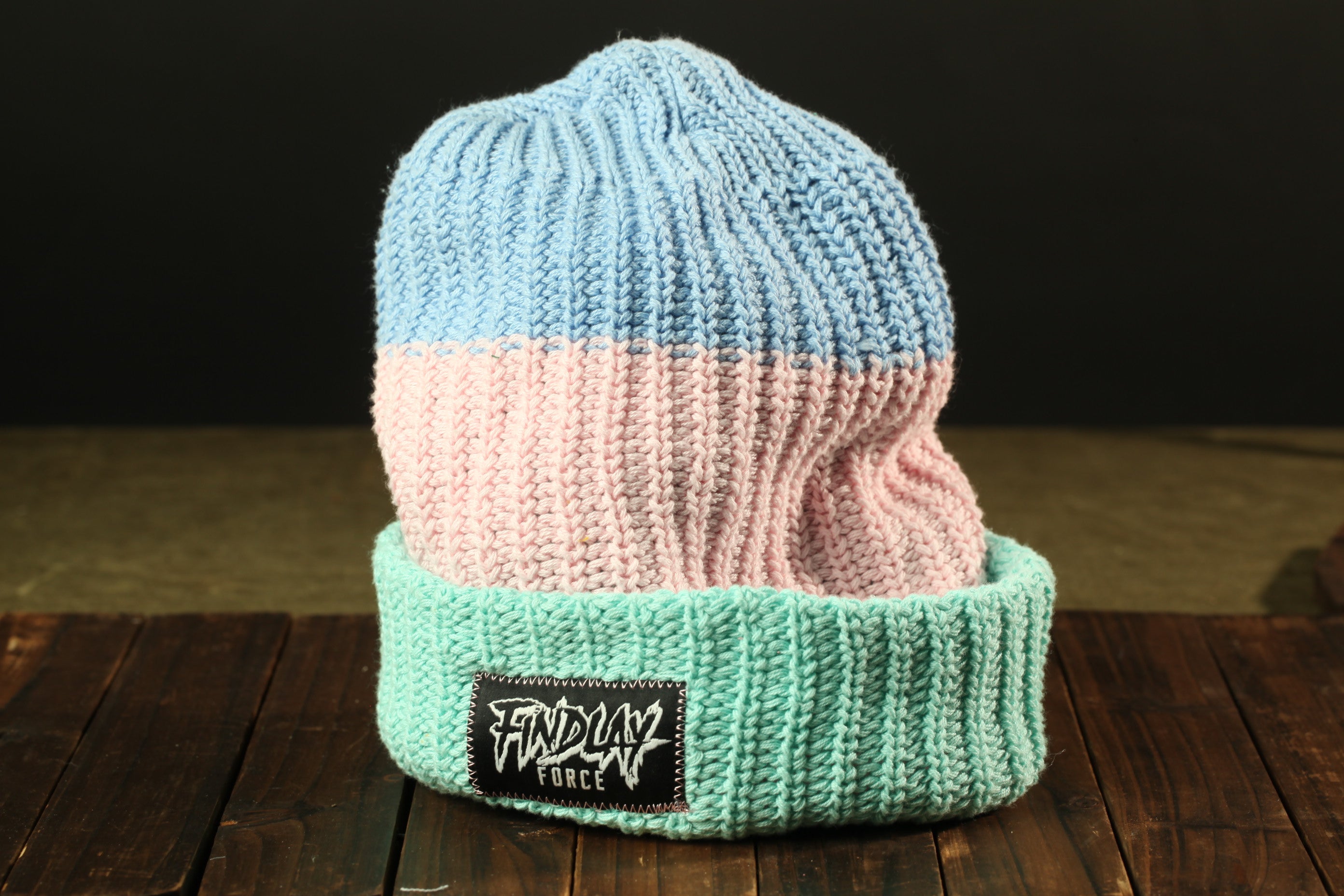 A knitted beanie with a blue and pink color scheme, featuring a label that reads "FINDlay Force".