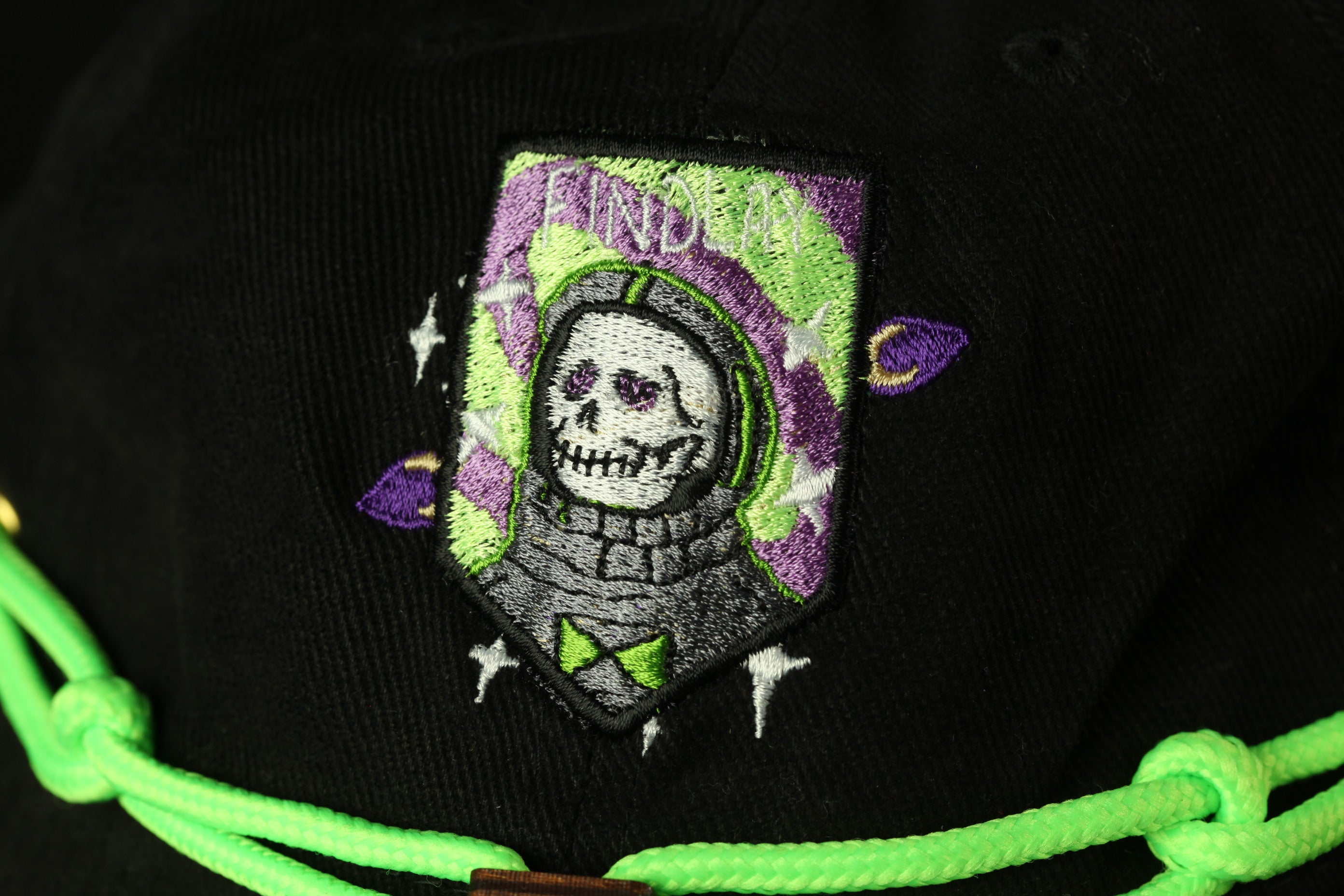 a close-up view of a black baseball cap with a colorful, embroidered patch on the front.