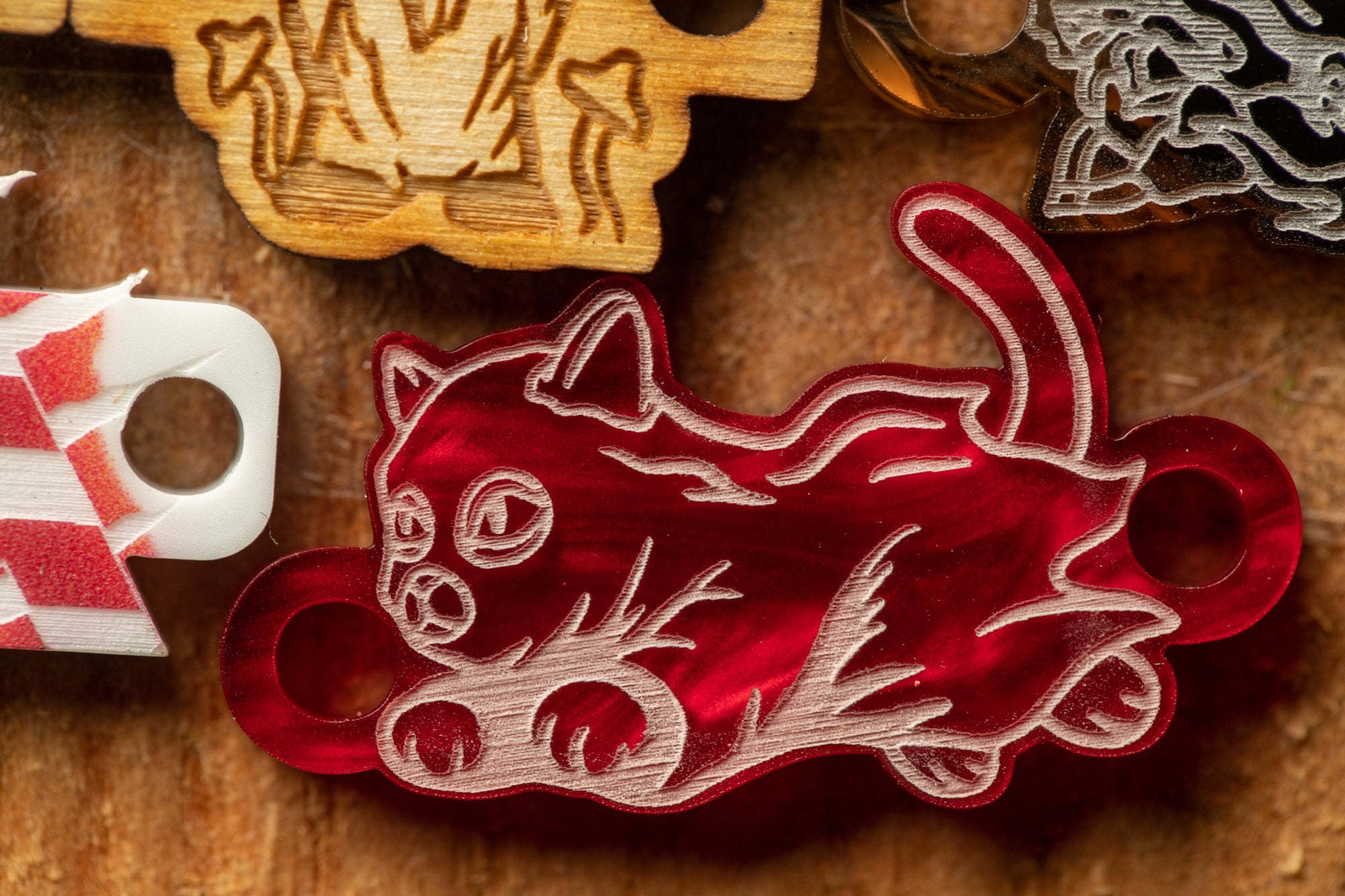 a close-up view of a red cat-shaped object with a white outline, sitting on a wooden surface.