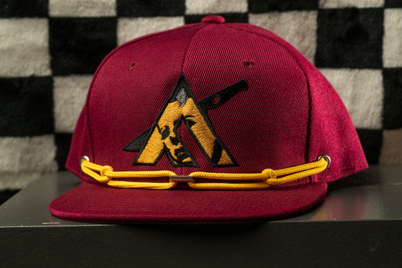 A maroon baseball cap with a yellow chain strap and a black and yellow logo on the front.