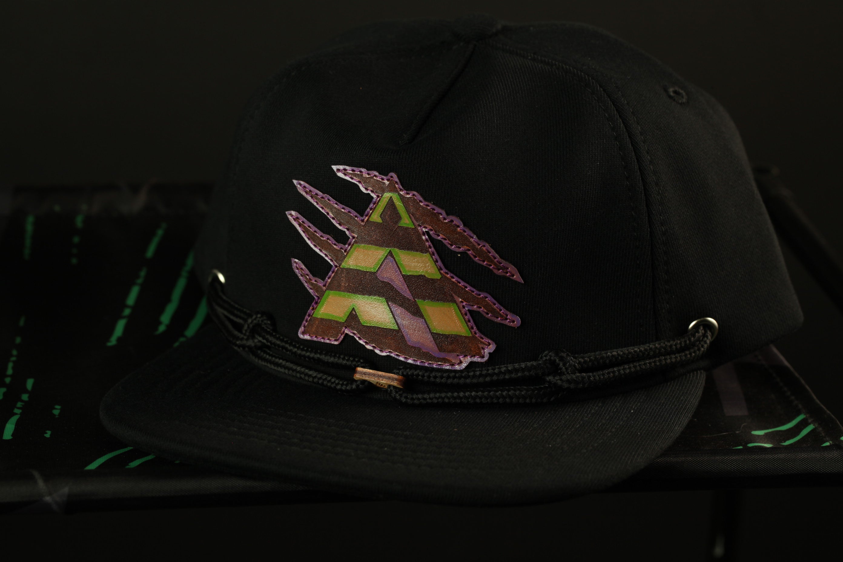 A black baseball cap with a colorful graphic design on the front.