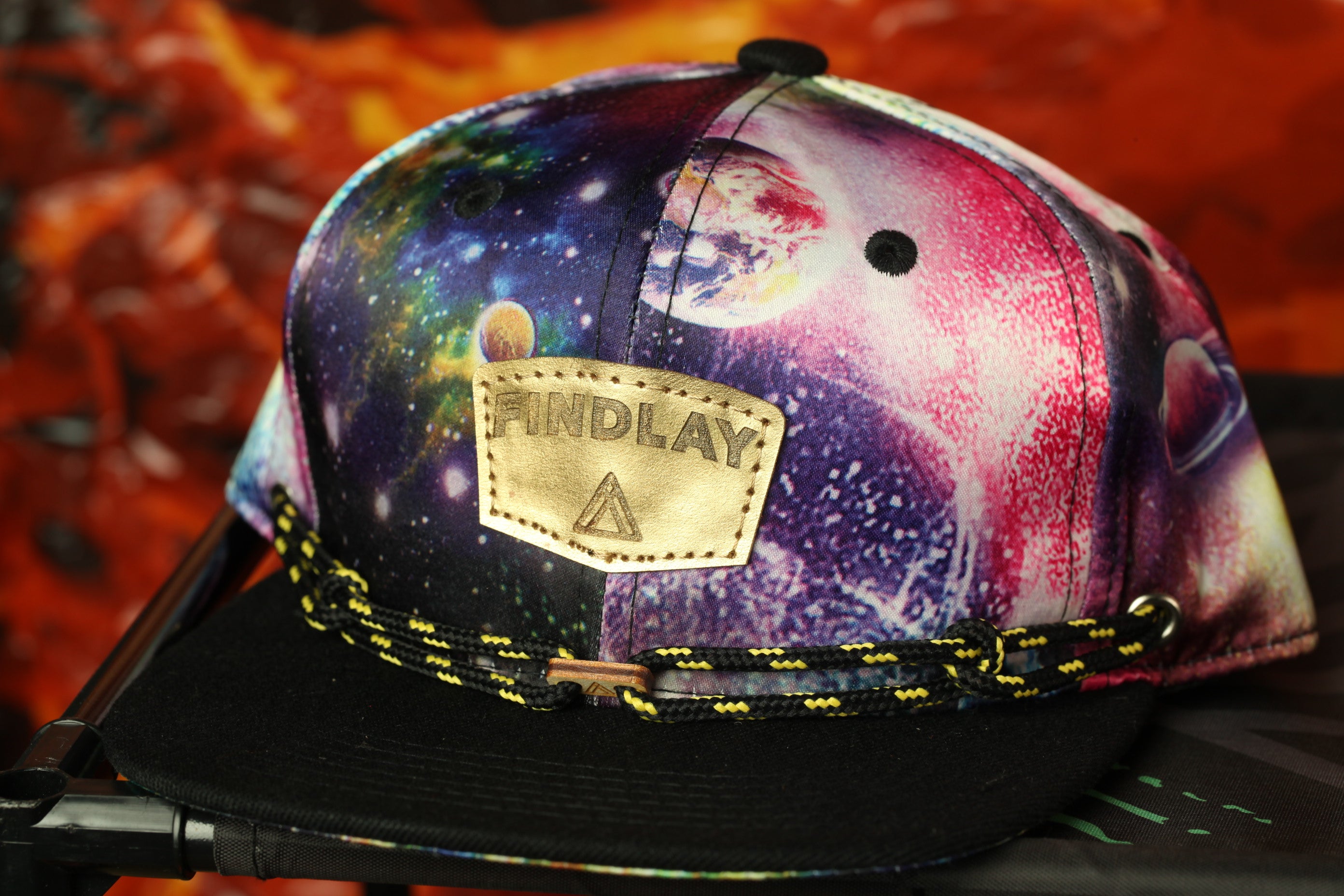 A colorful, patterned baseball cap with a black brim and a black and yellow string.