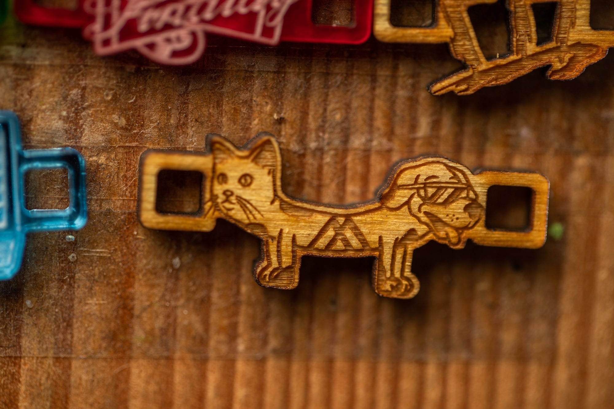 a wooden object with a cat and dog design, which appears to be a decorative piece or a craft item.
