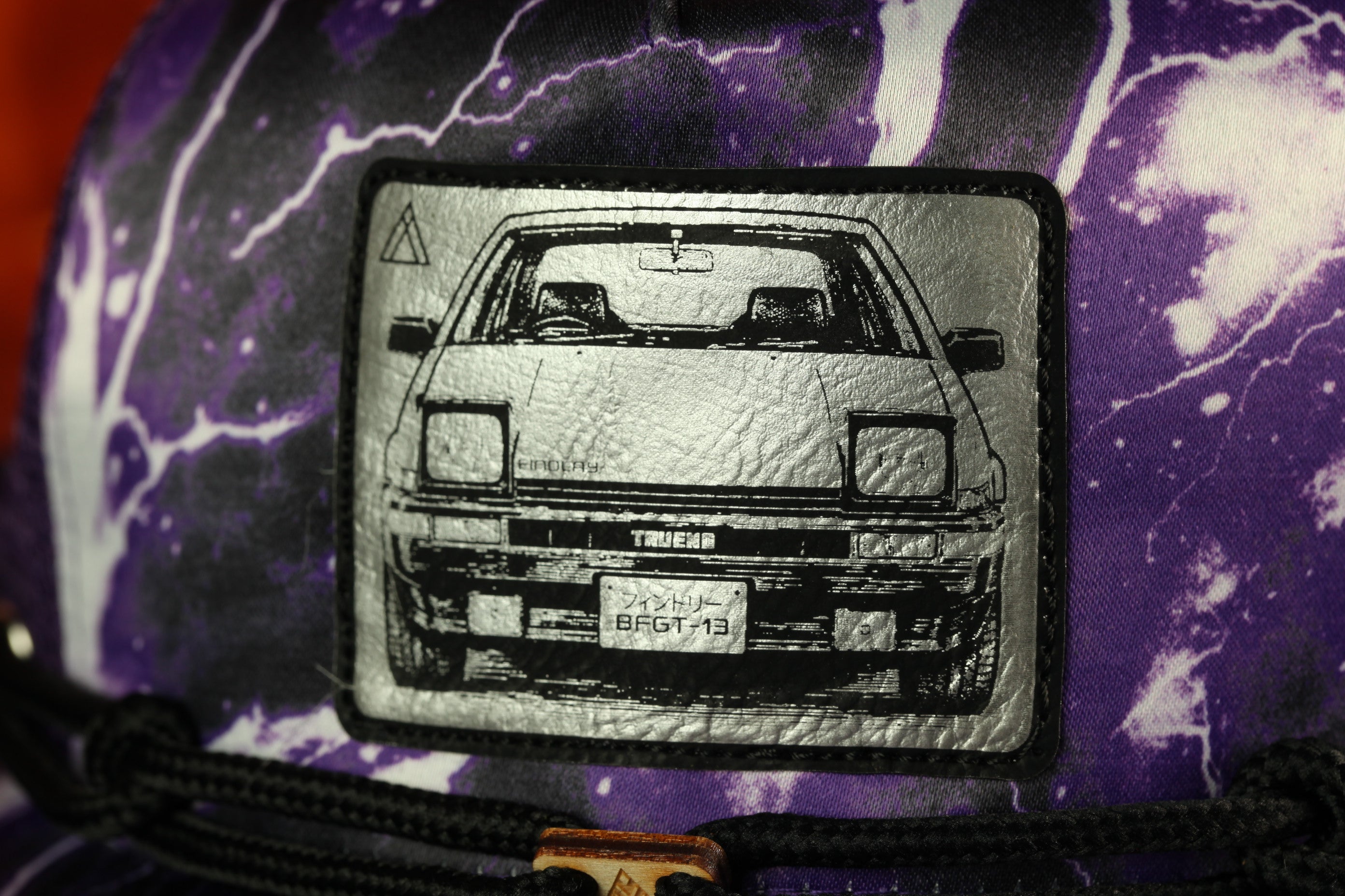 a close-up of a car on a purple and white patterned fabric.