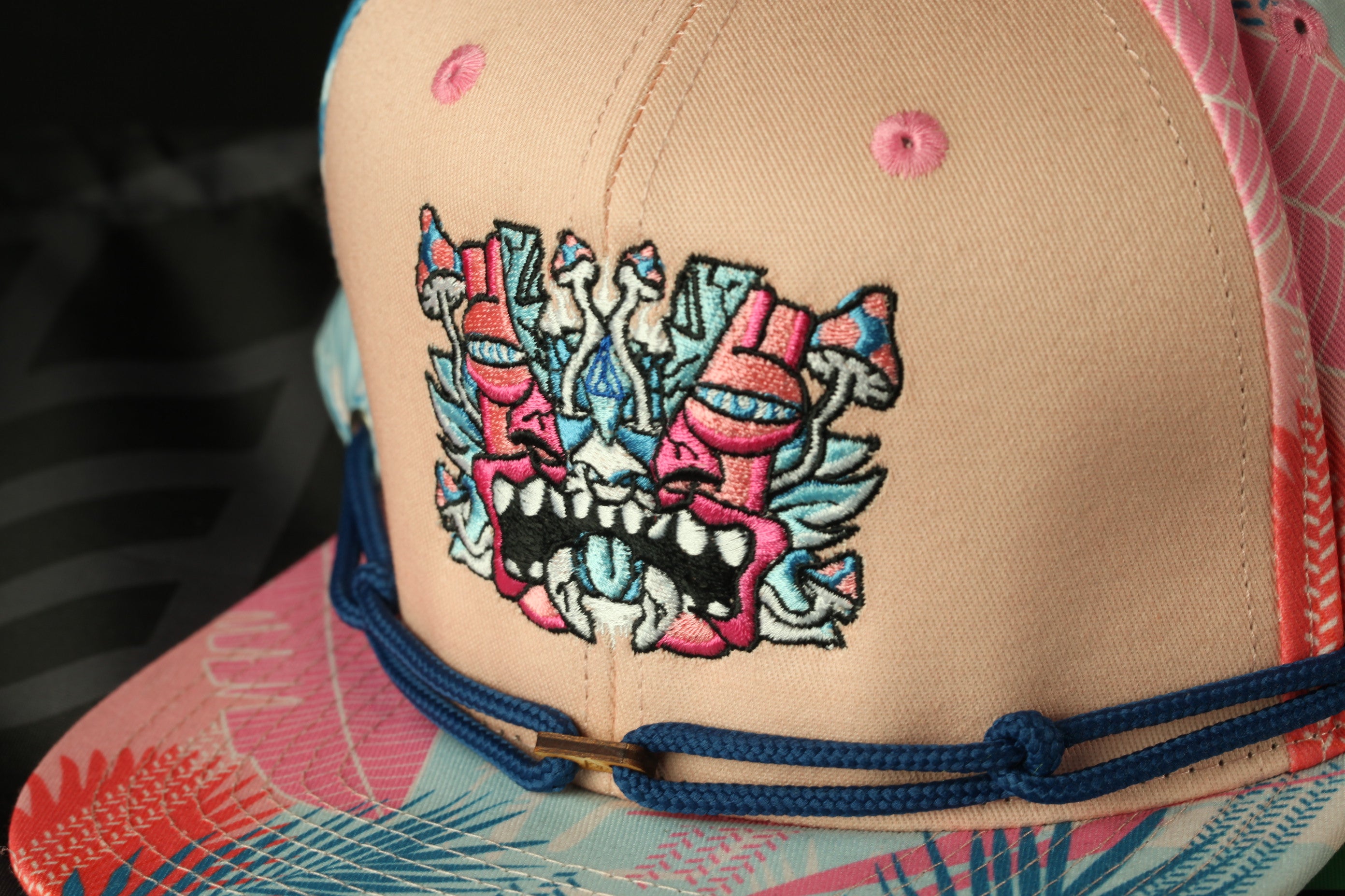 A close-up view of a baseball cap with a colorful, embroidered design on the front.