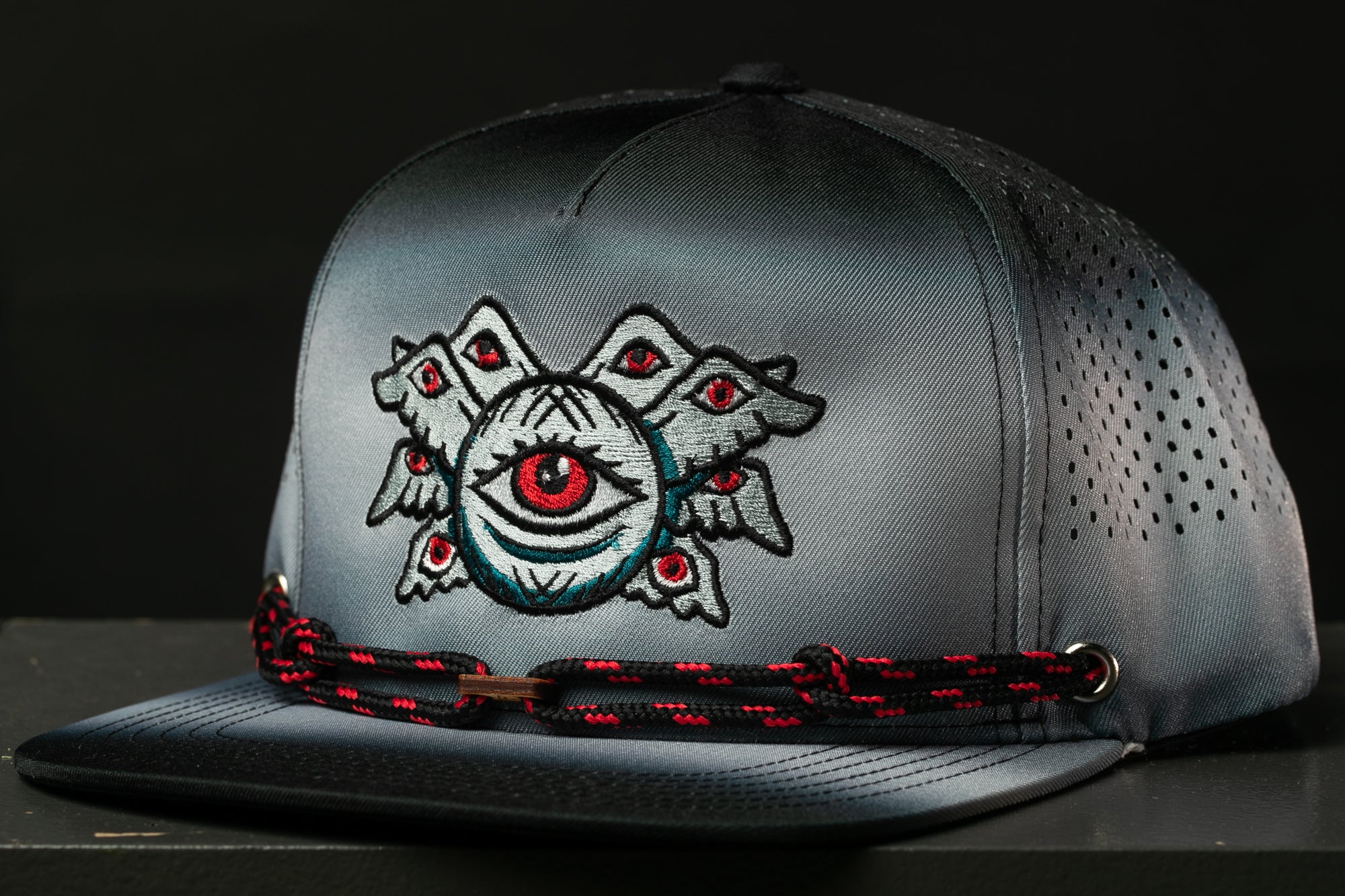 A gray baseball cap with a unique eye design on the front.
