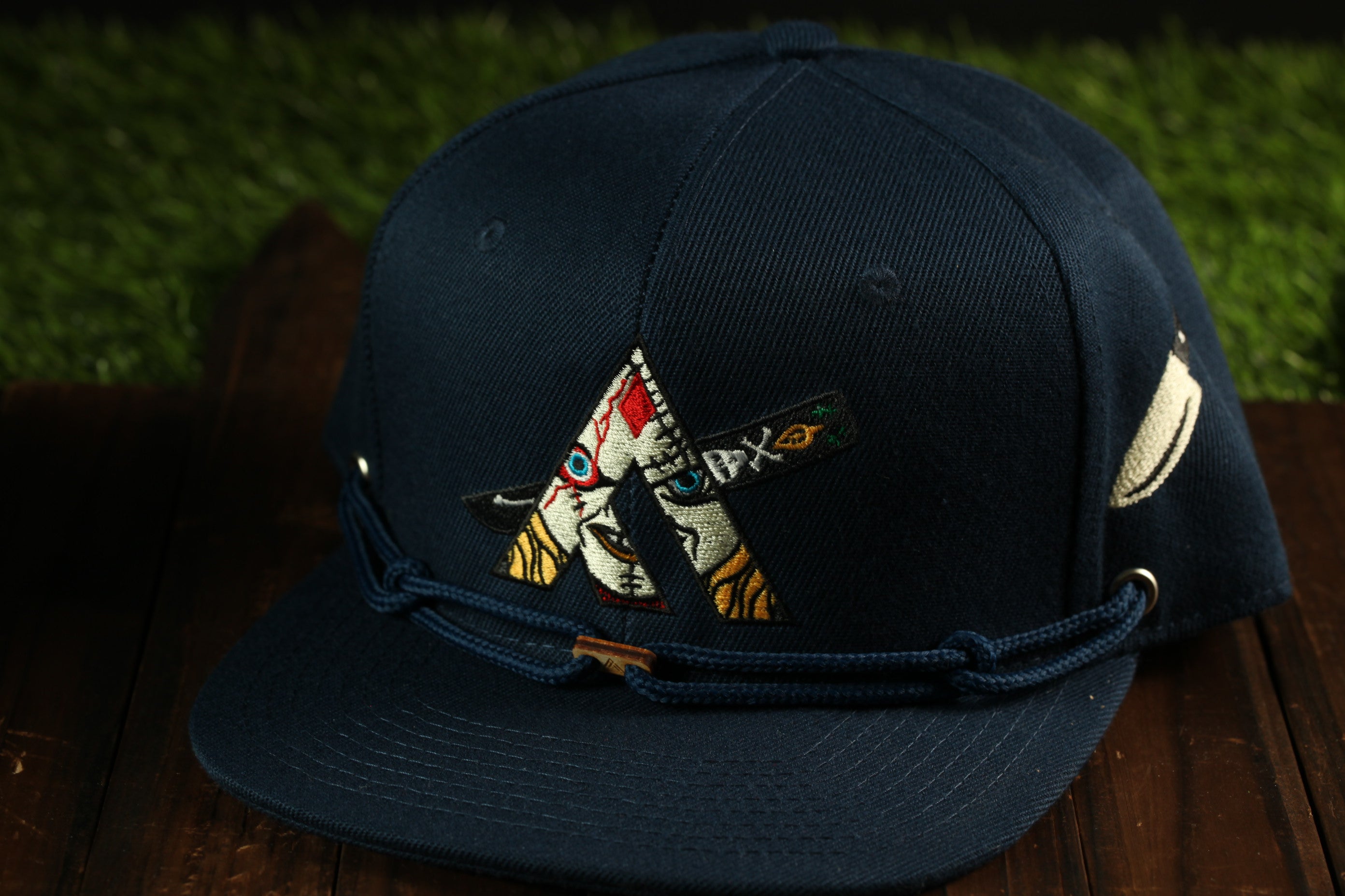 A navy blue baseball cap with a colorful, embroidered design on the front.