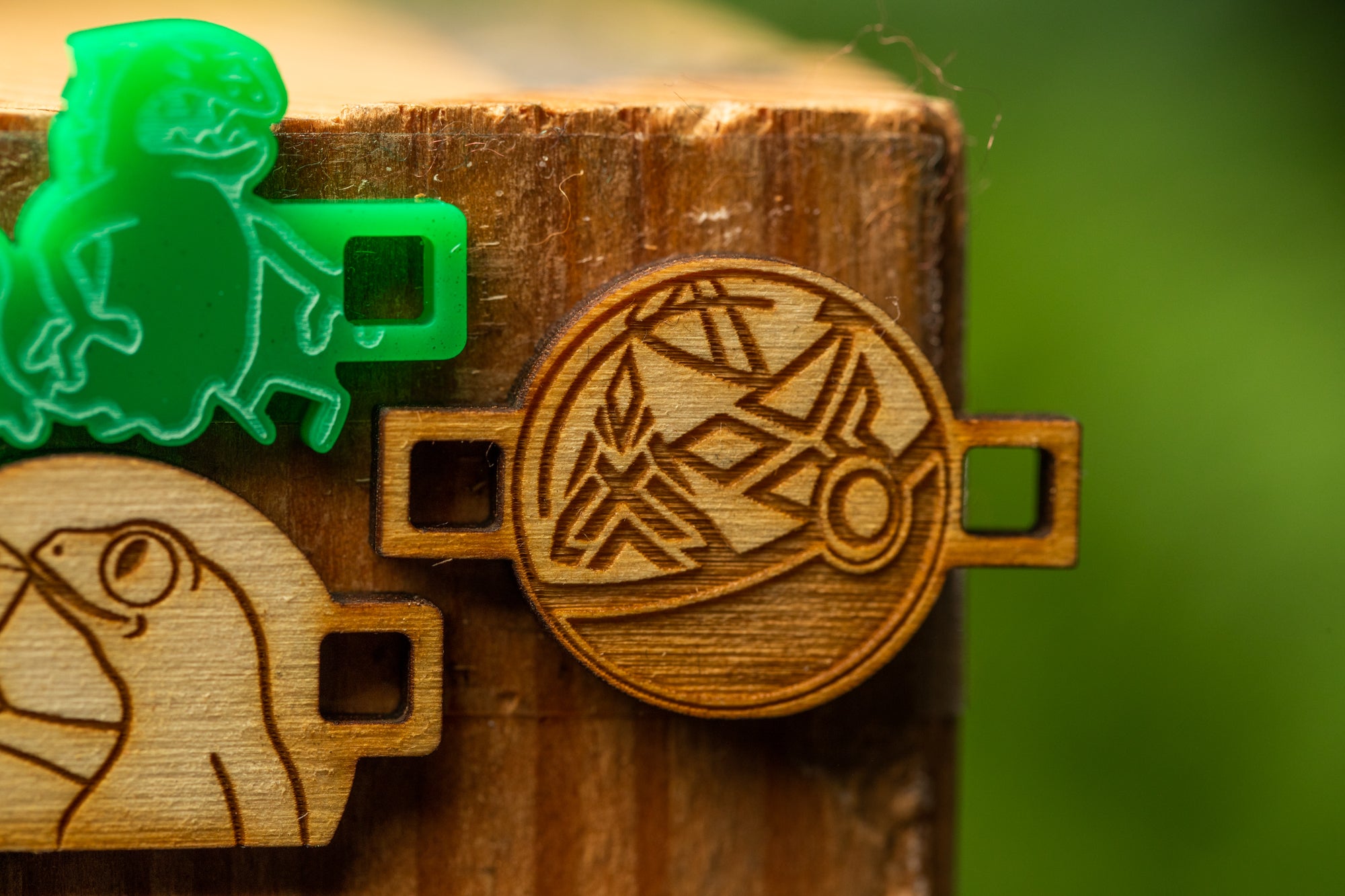 a wooden object with a carved design, including a green plastic object with a similar design.