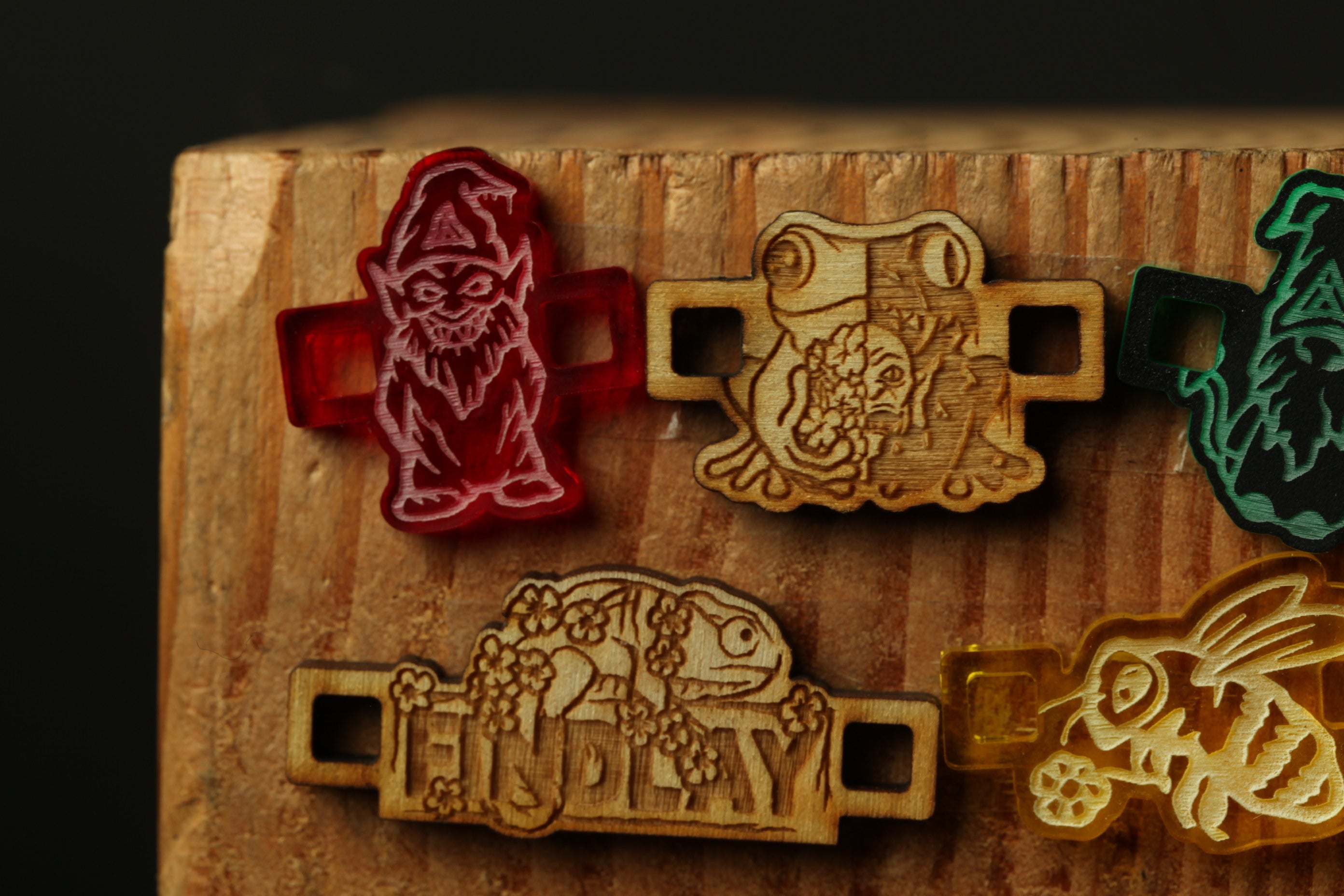 a collection of wooden charms or stickers with various animal designs, including a gnome, frog, and other creatures.