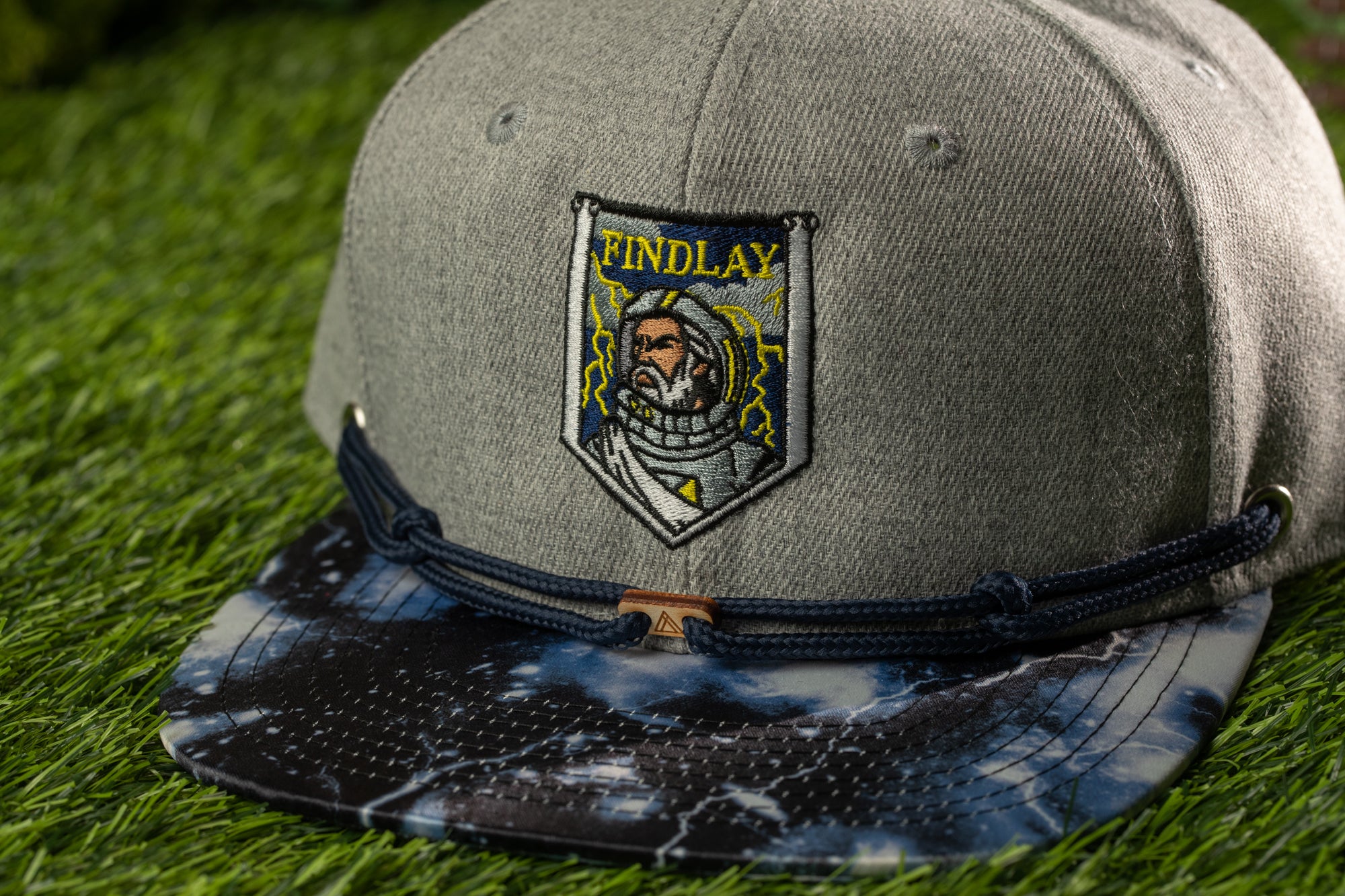 A gray baseball cap with a blue and white tie-dye pattern and a patch on the front that says "FINDAY".