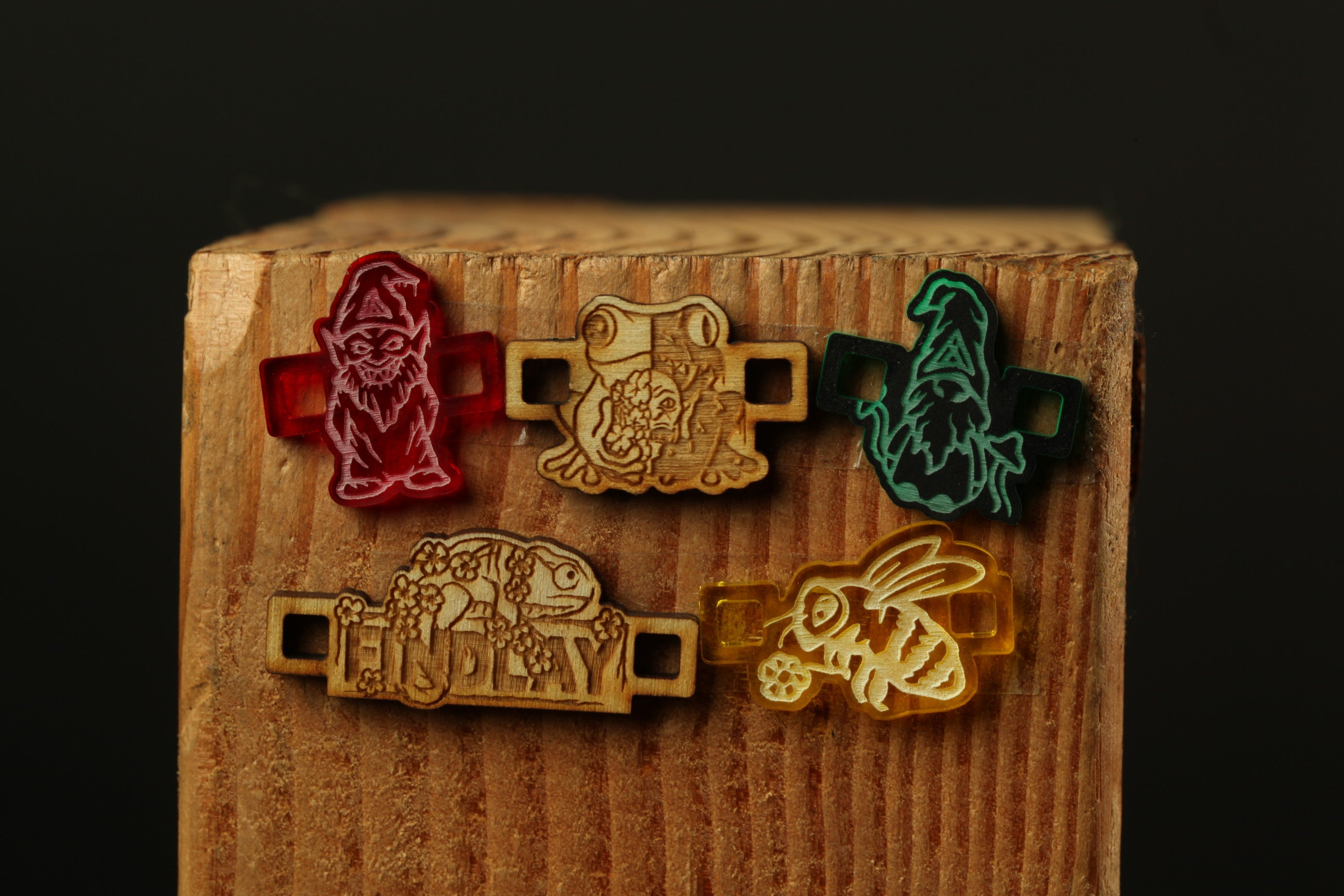 five colorful, hand-carved wooden shoe stretchers with various animal designs, including a gnome, frog, dragon, bee, and a bird.