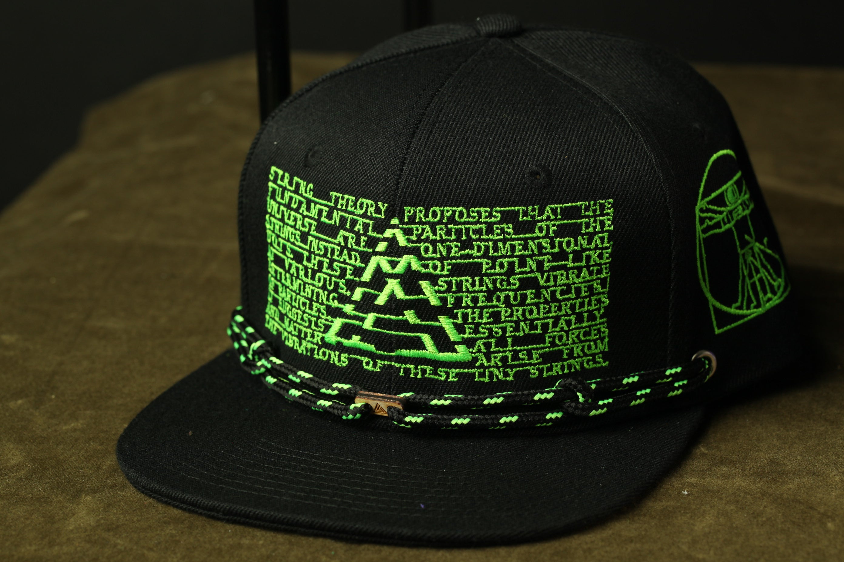 A black baseball cap with green text and graphics on it.