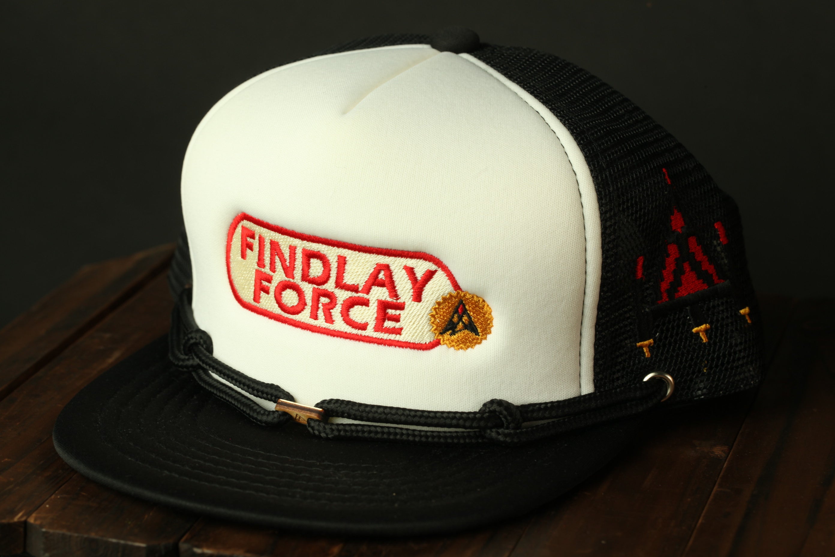 A white baseball cap with the text "FINDLAY FORCE" printed on it, along with a small circular logo.