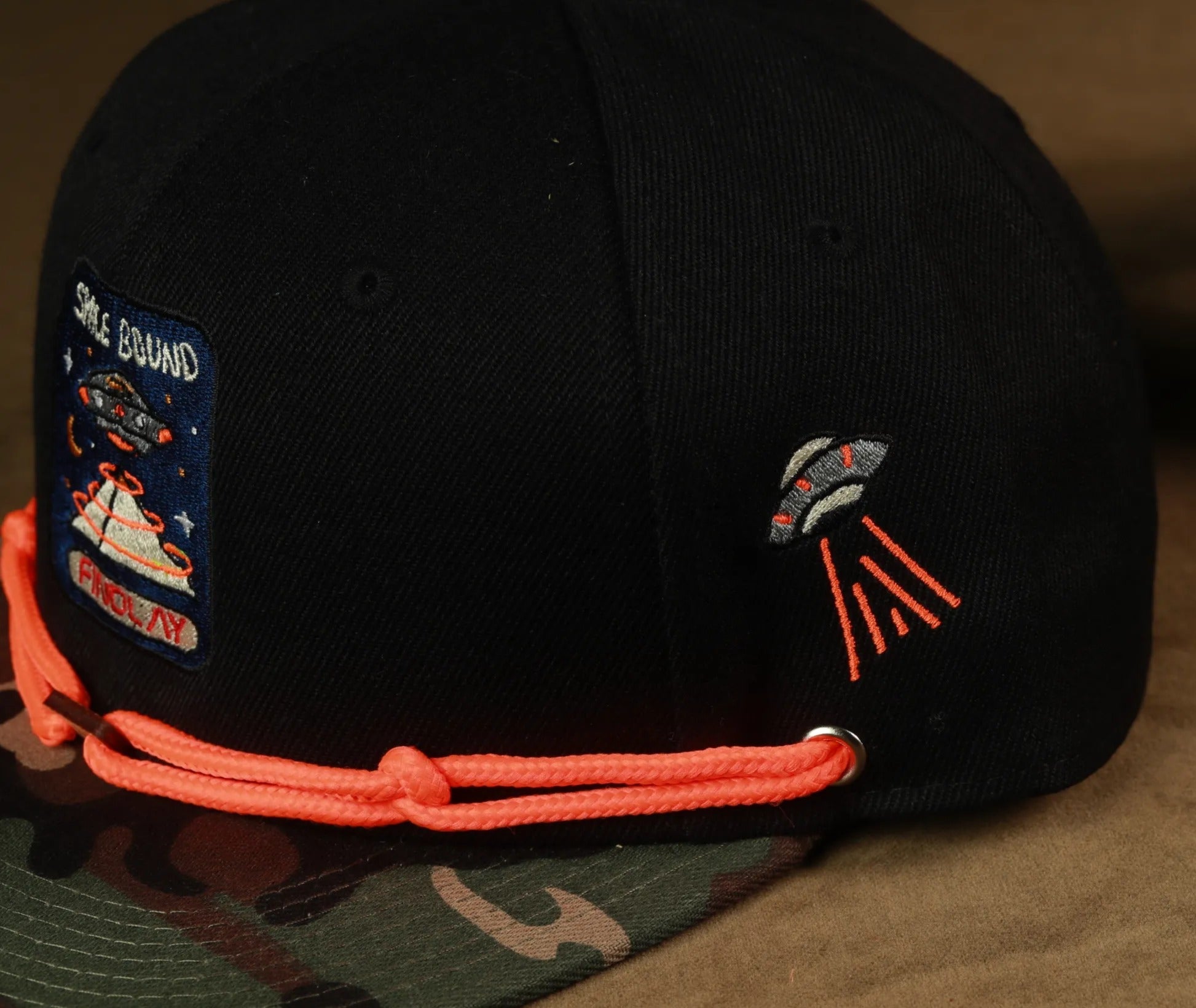 two baseball caps, one black and one gray, with various patches and designs on them.