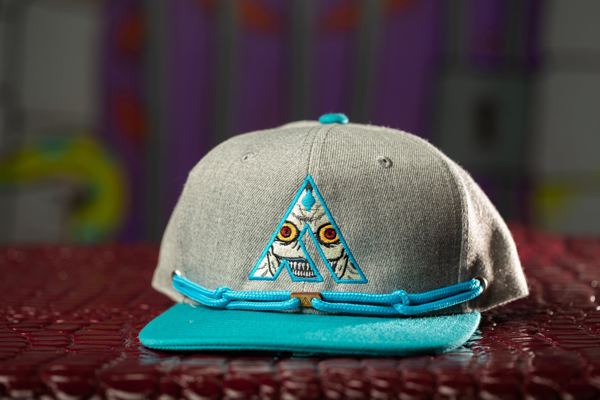 a grey and blue hat with a triangle on it