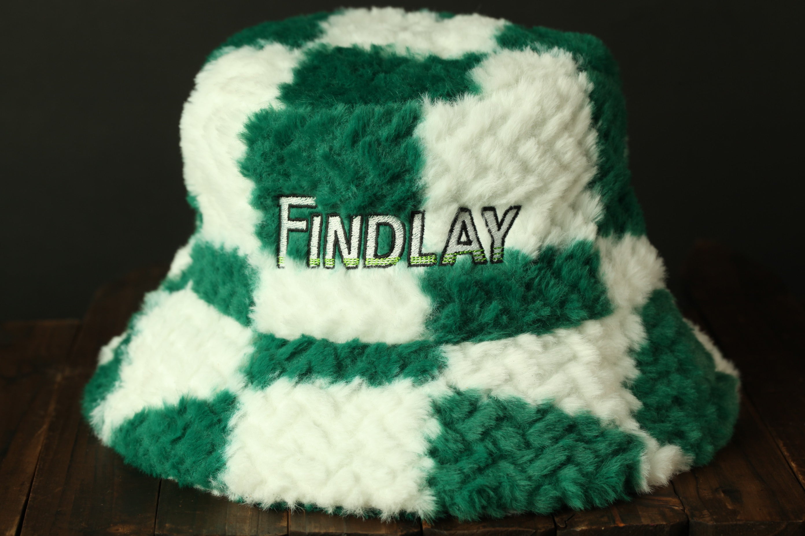 A green and white checkered bucket hat with the word "Findlay" embroidered on it.