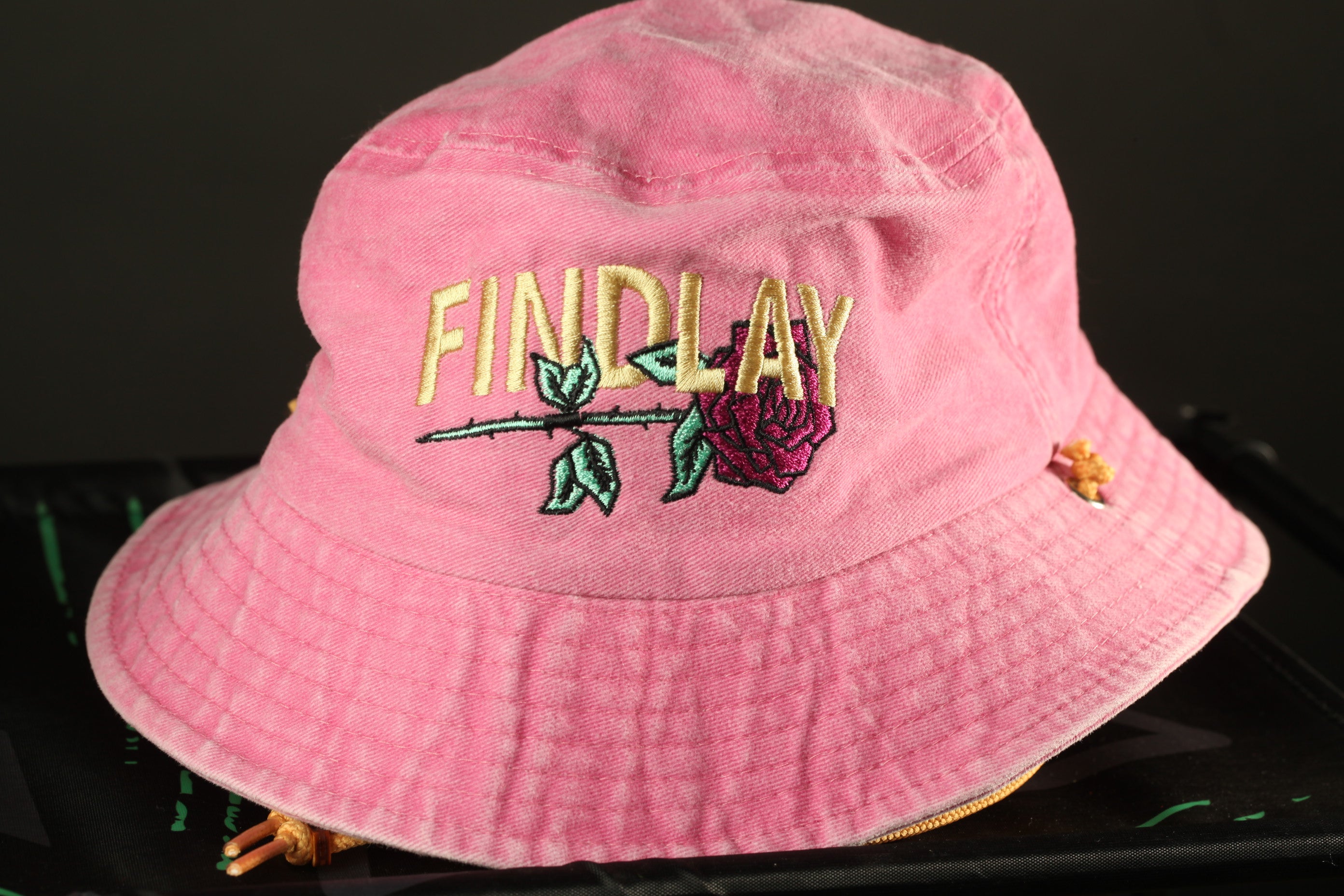 A pink bucket hat with the word "FINDlay" embroidered on it.