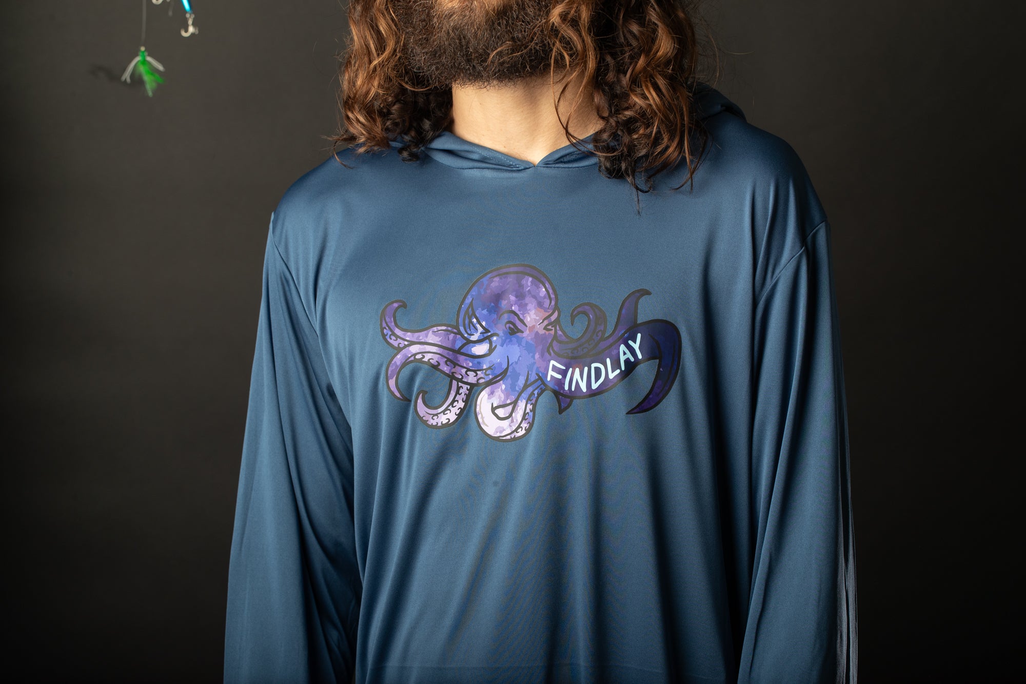 a man with long hair wearing a blue shirt