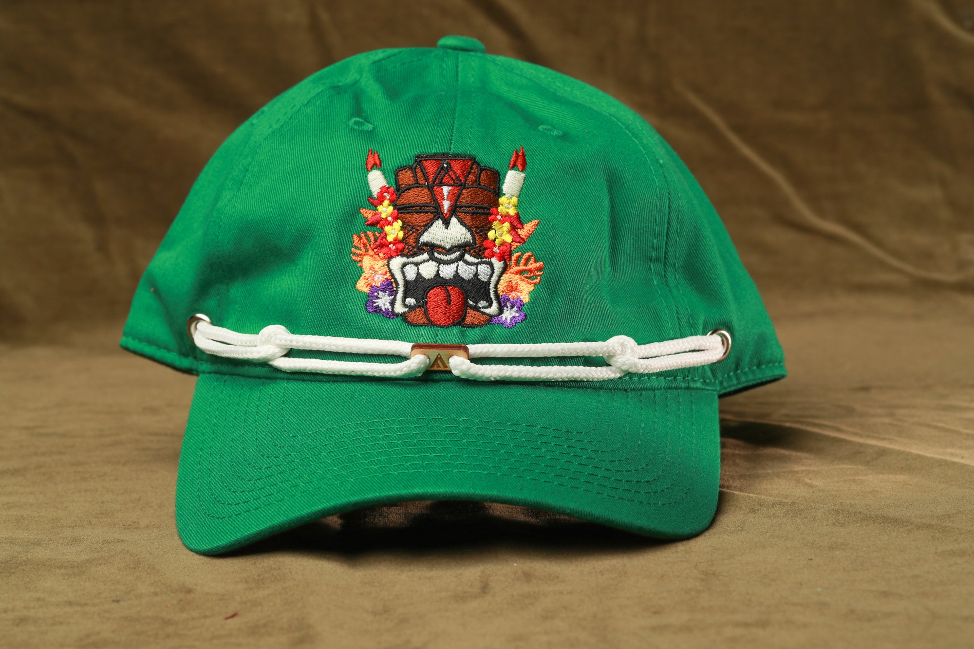 A green baseball cap with a colorful, cartoonish design on the front.