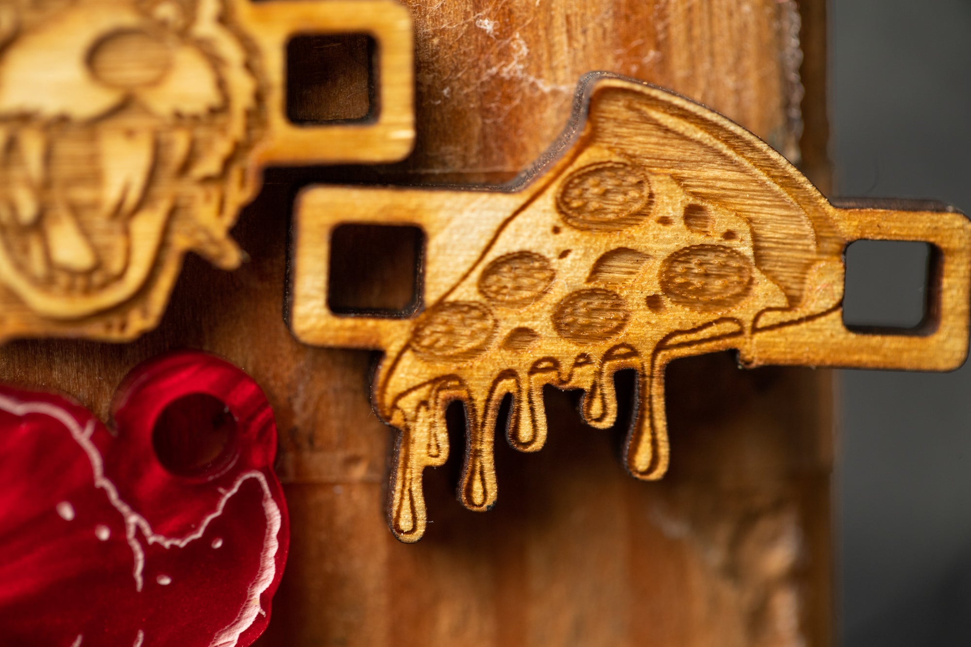 a close-up view of a wooden object with a pizza slice design, including melted cheese dripping down the sides.