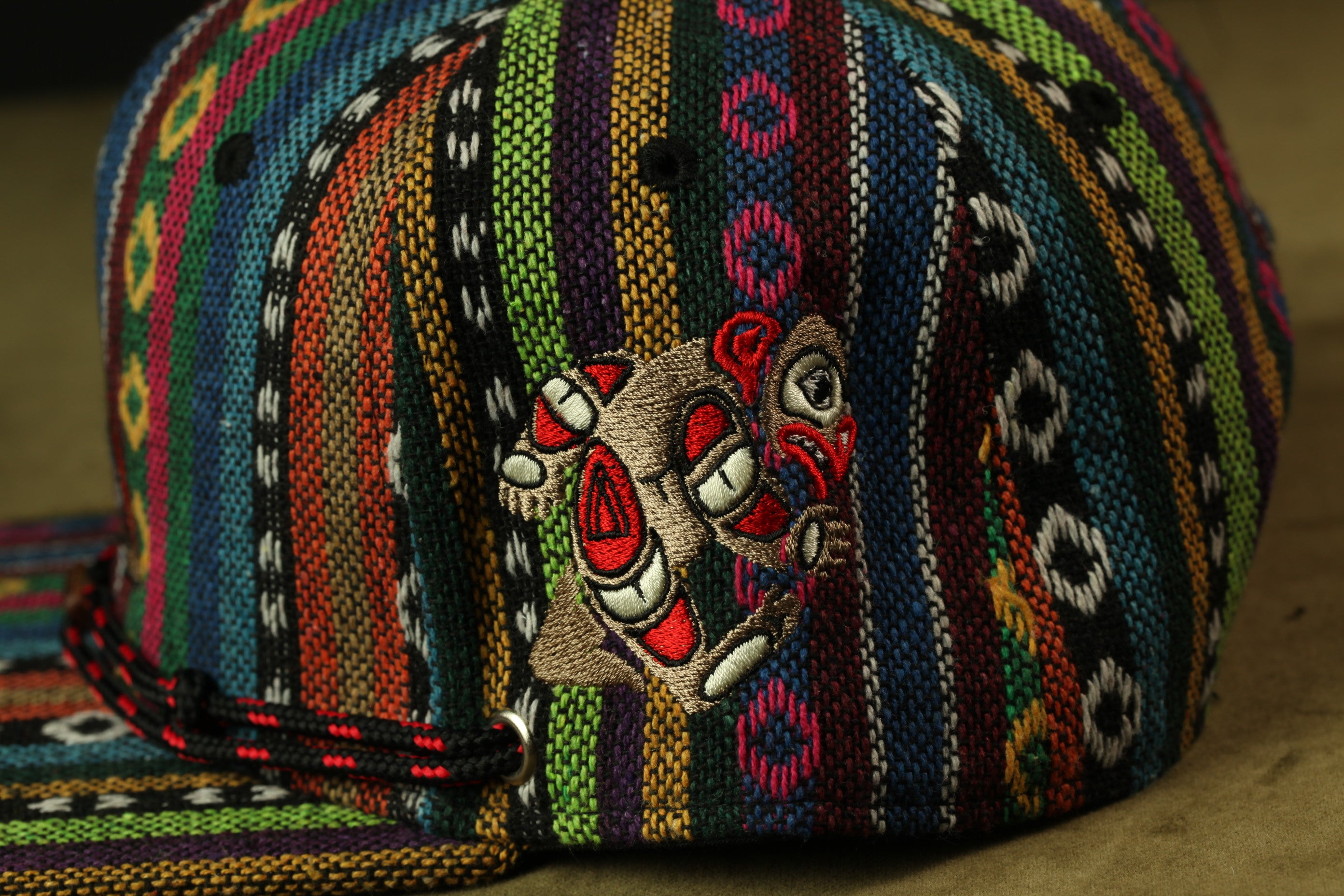 A colorful, patterned baseball cap with a unique embroidered design on the front.