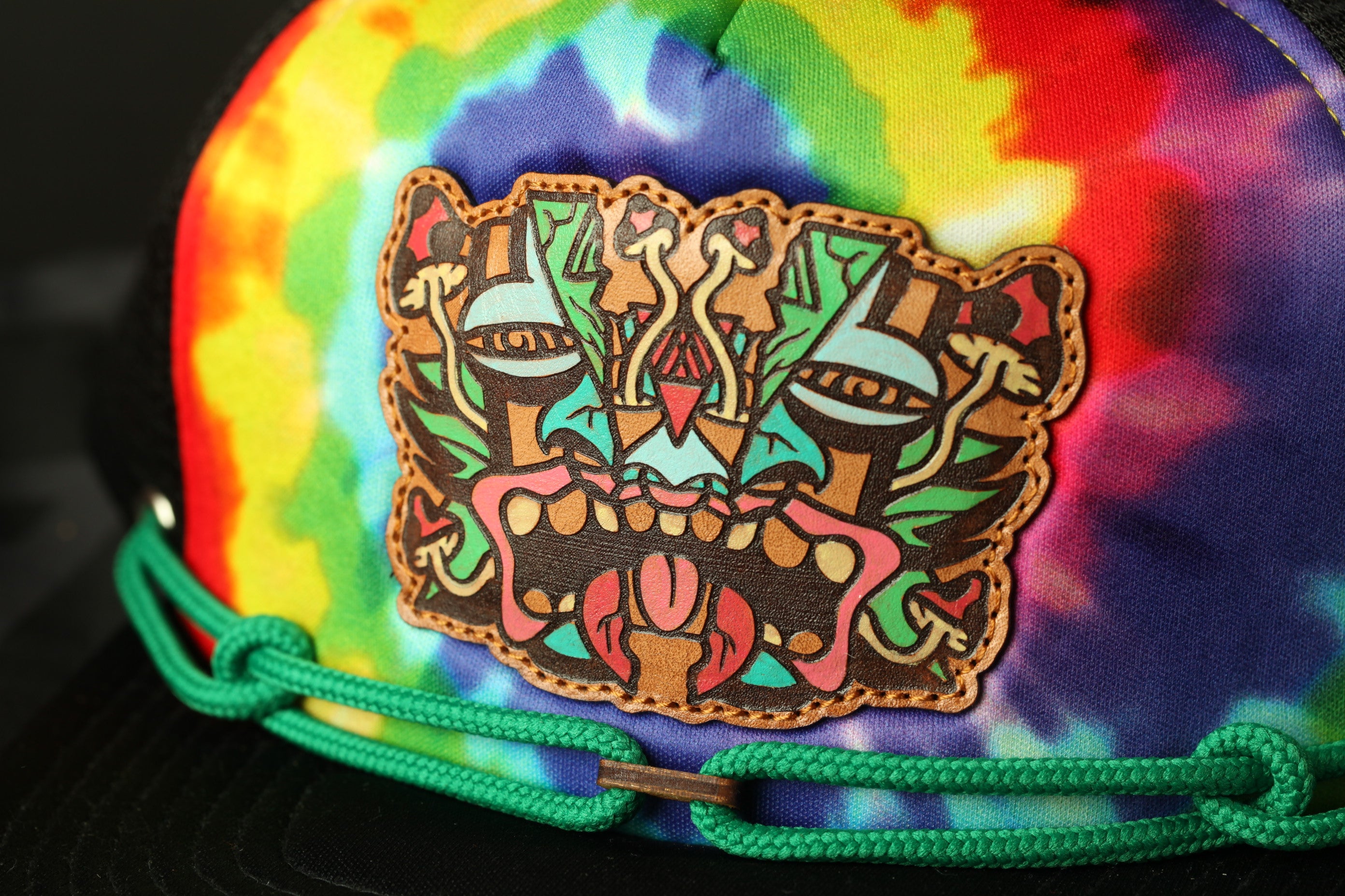 A colorful tie-dye baseball cap with a unique, abstract design on the front.
