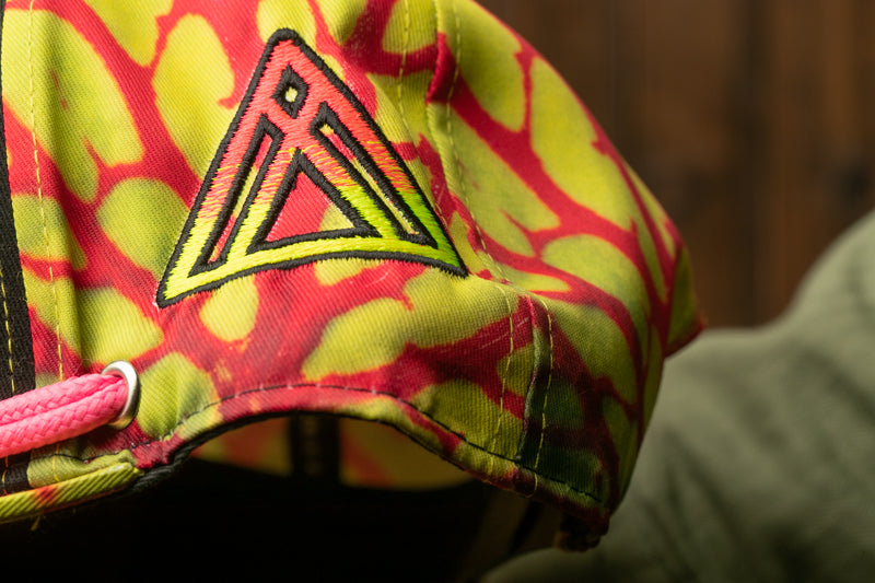 A close-up view of a colorful, patterned hat with a distinctive logo on the front.