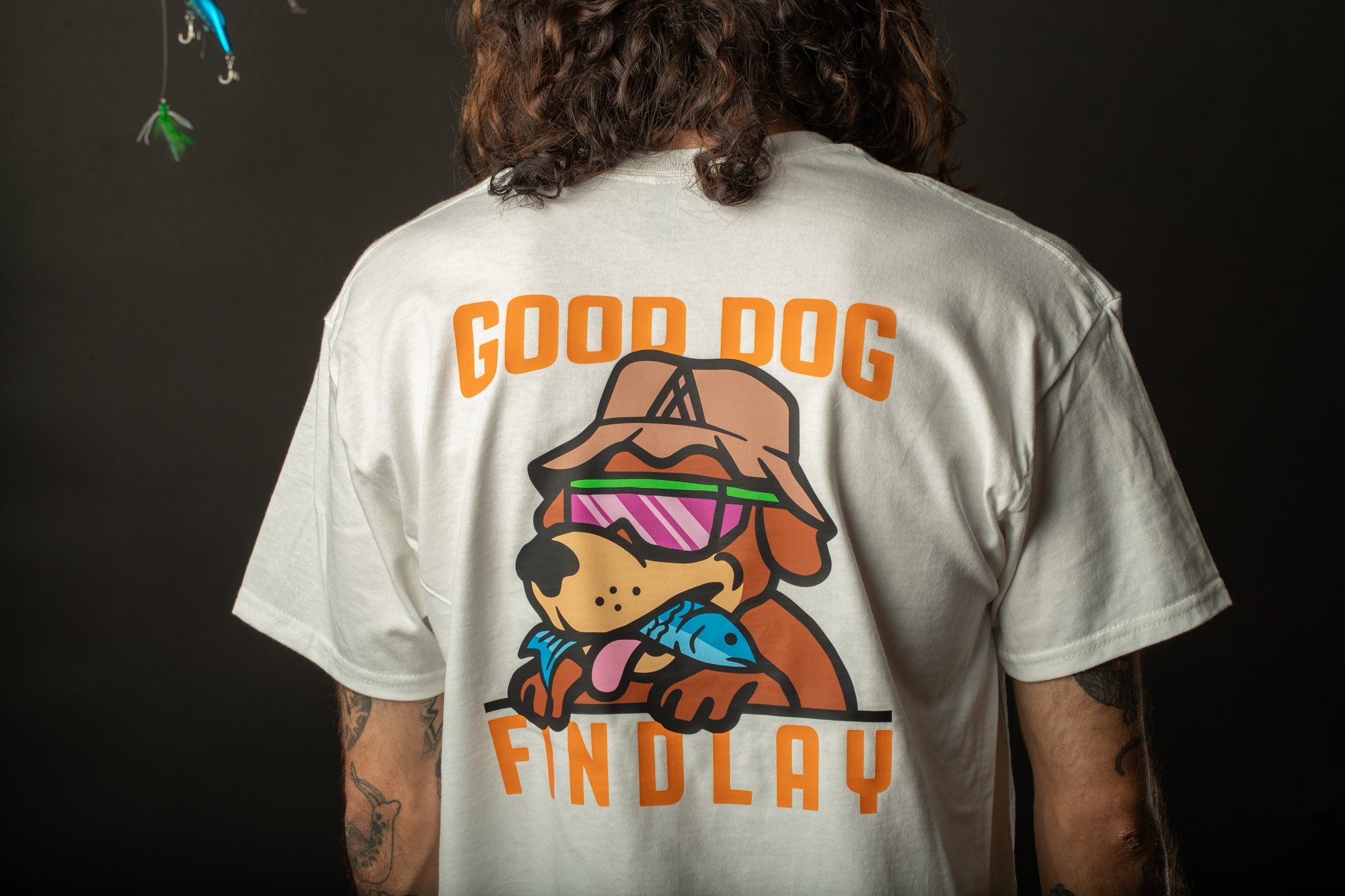 a man with long hair wearing a t - shirt with a dog on it