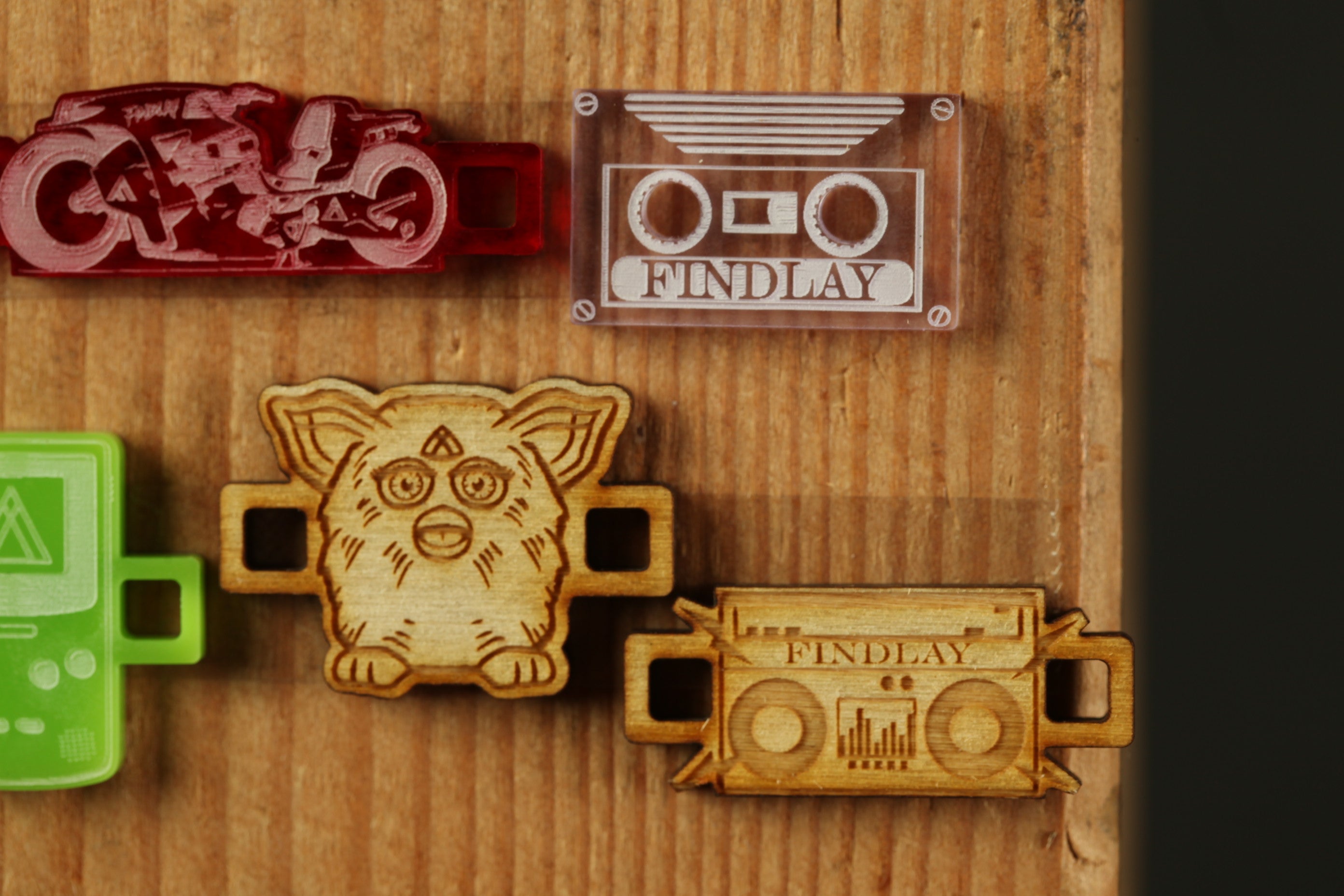 a collection of various wooden objects, including a red object resembling a toy motorcycle, a clear object resembling a cassette tape, and a wooden object resembling a toy teddy bear.