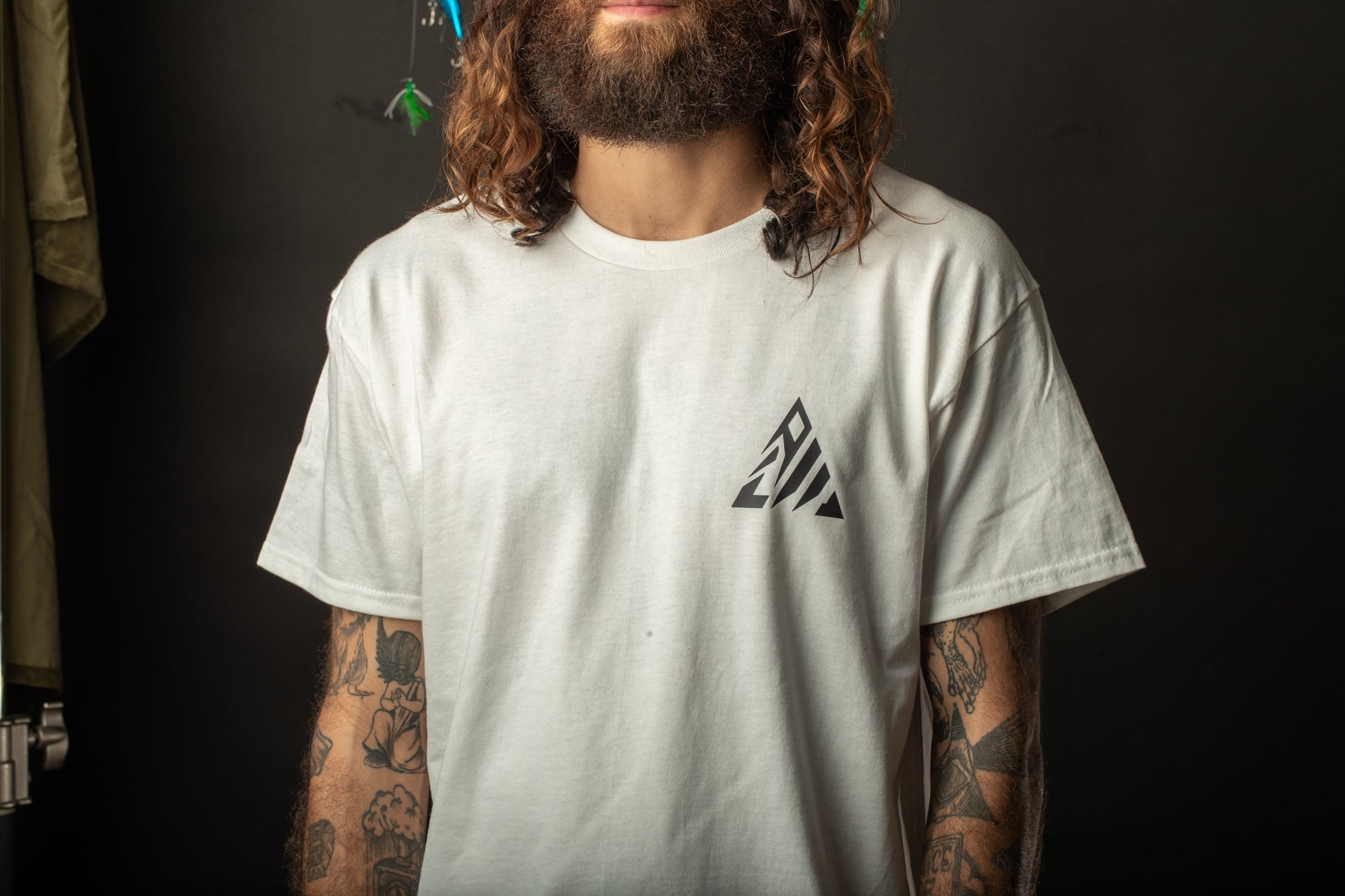 a man with long hair and a beard wearing a white shirt