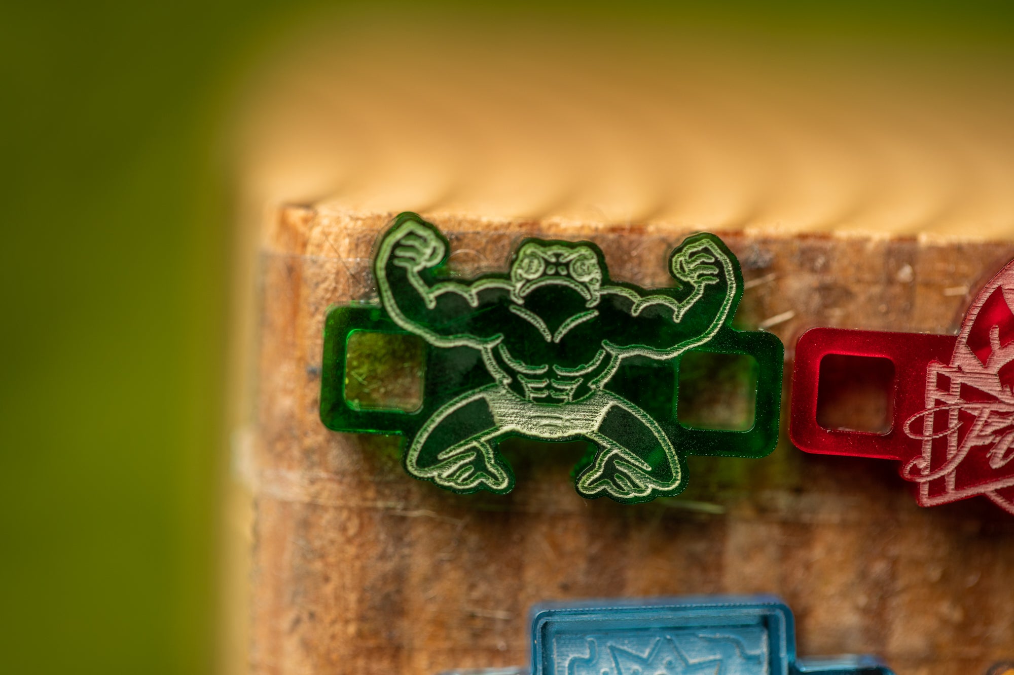 a close-up view of a green plastic object with a muscular design, placed on a brown surface.