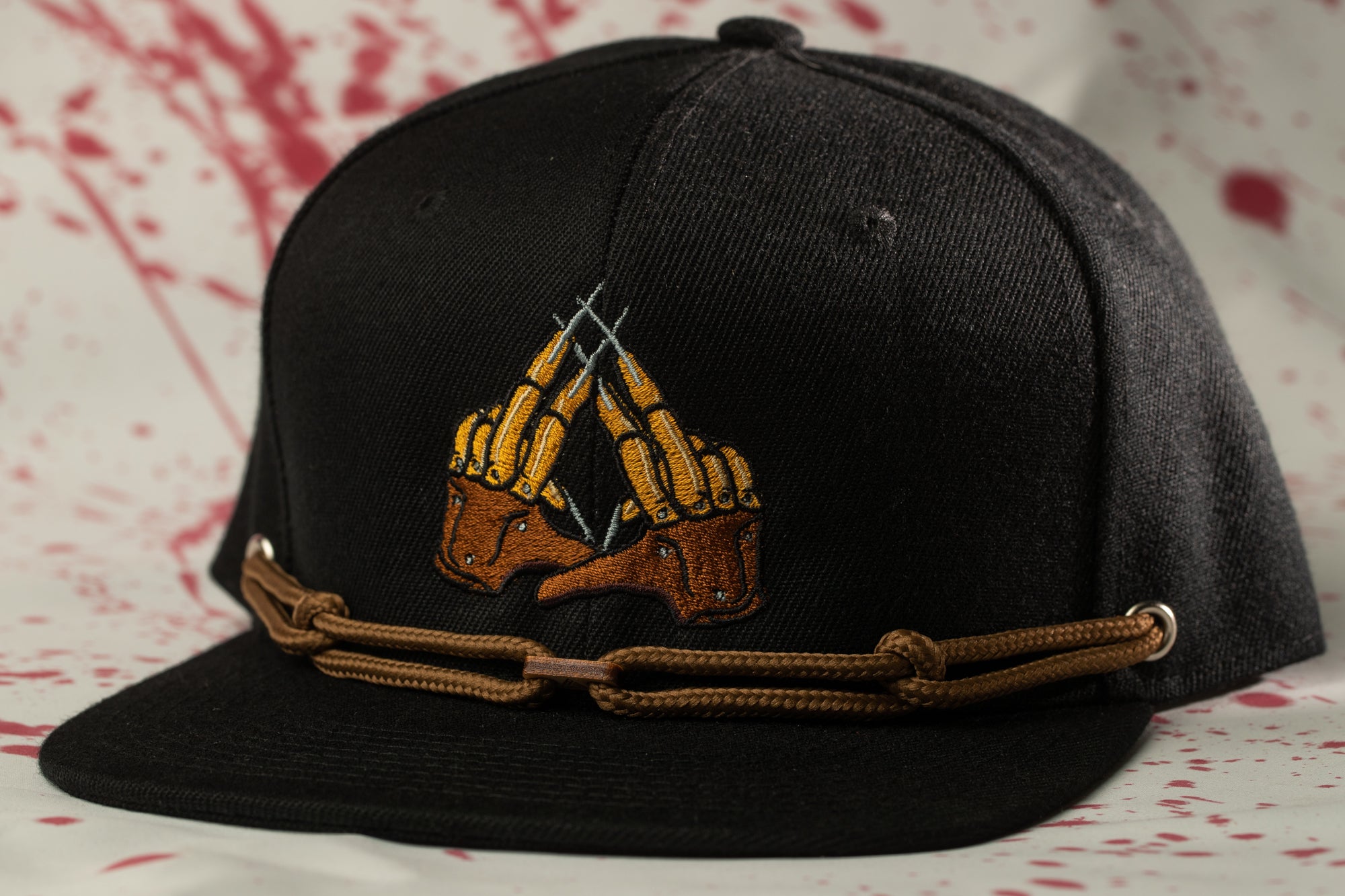 A black baseball cap with a unique embroidered design on the front.
