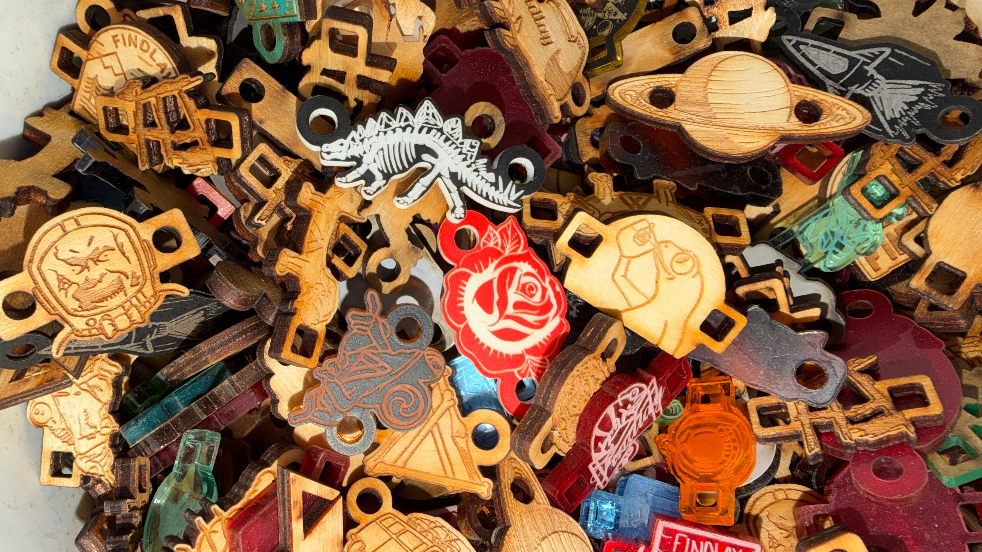 a variety of wooden objects, including a dinosaur, a planet, and other shapes and designs, all of which appear to be made of wood.