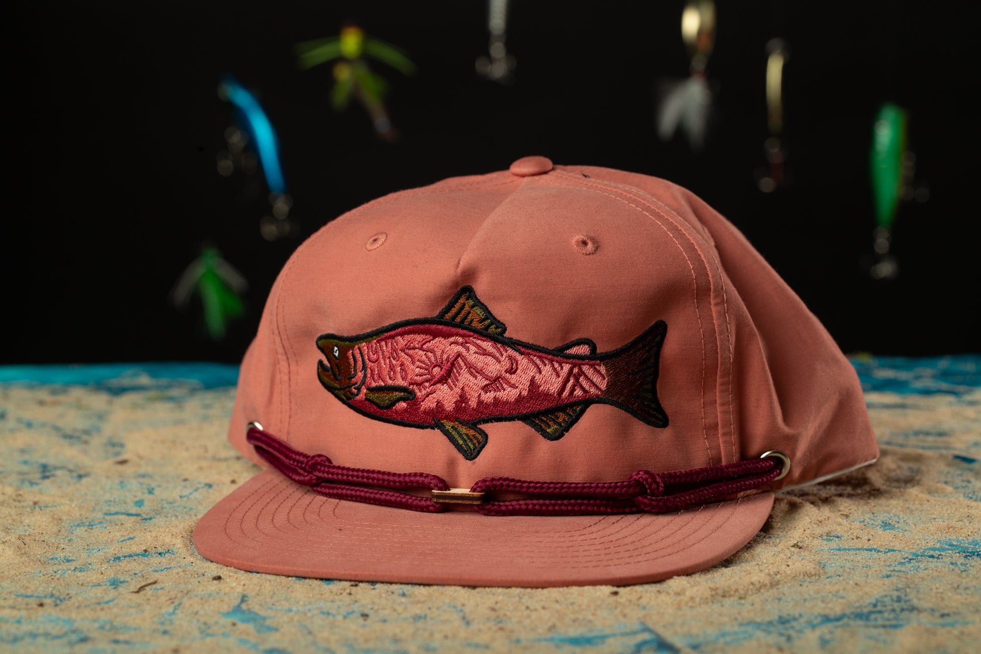 a pink hat with a fish embroidered on it