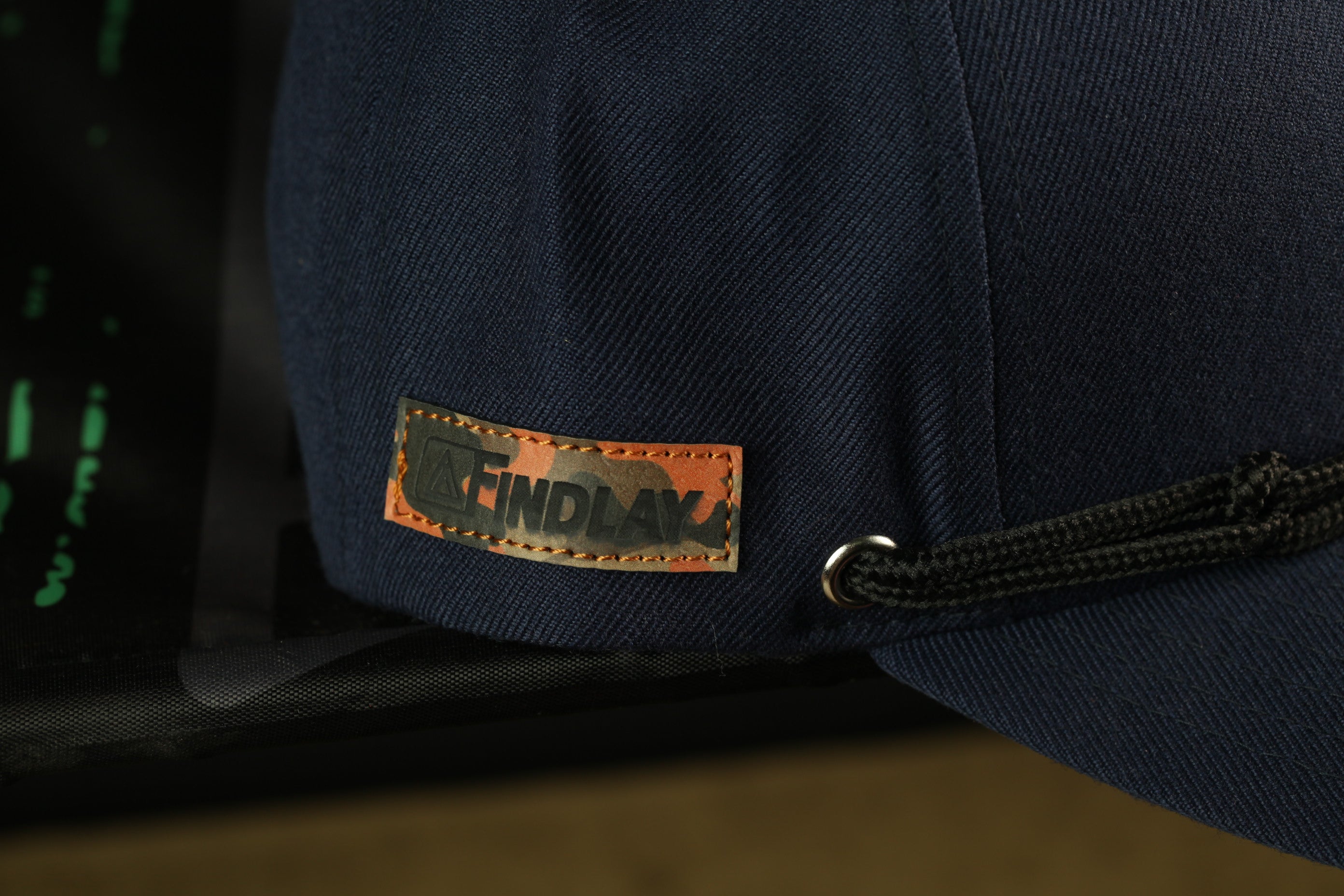 A close-up view of a navy blue baseball cap with a label that says "FINDLAK".