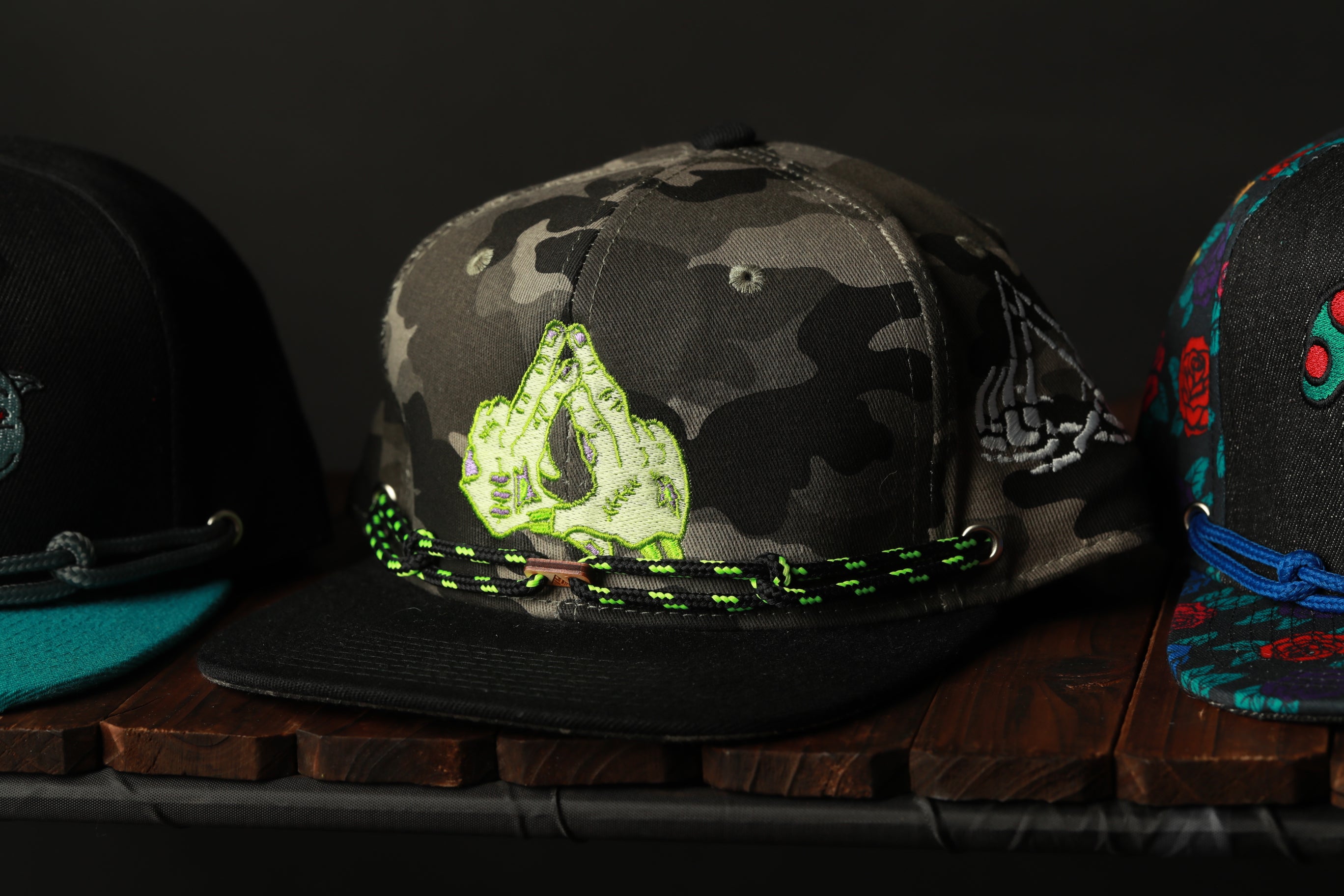 A collection of colorful baseball caps displayed on a wooden surface.