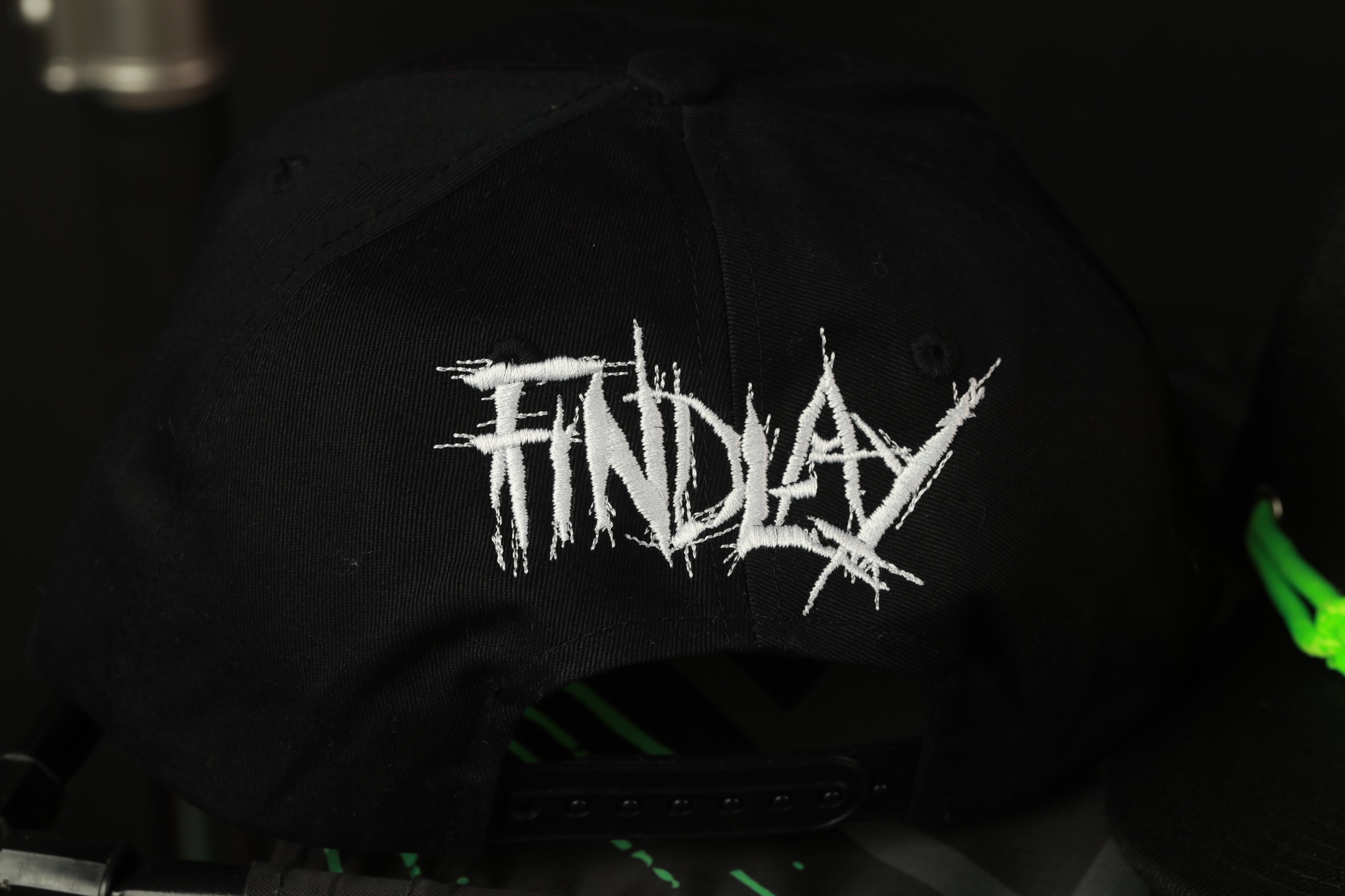 a black baseball cap with white text embroidered on it.
