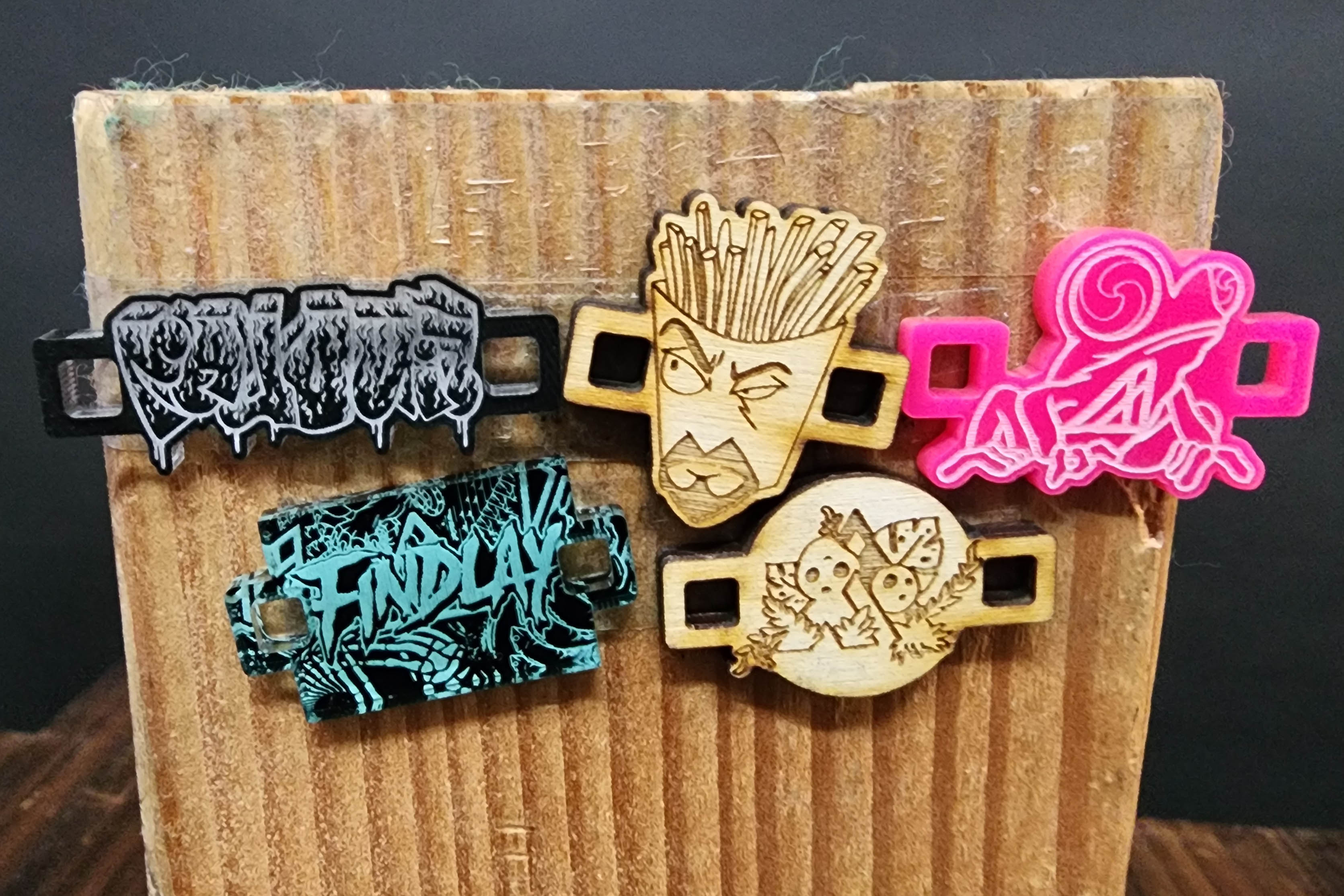 a wooden surface with five different wooden objects attached to it, each with a unique design or pattern.