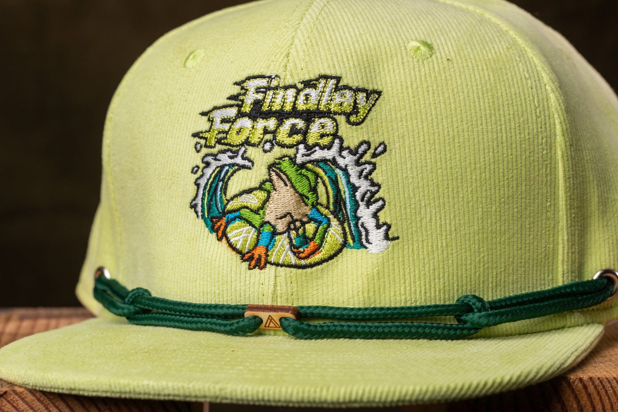 A yellow baseball cap with a green strap and a logo on the front.