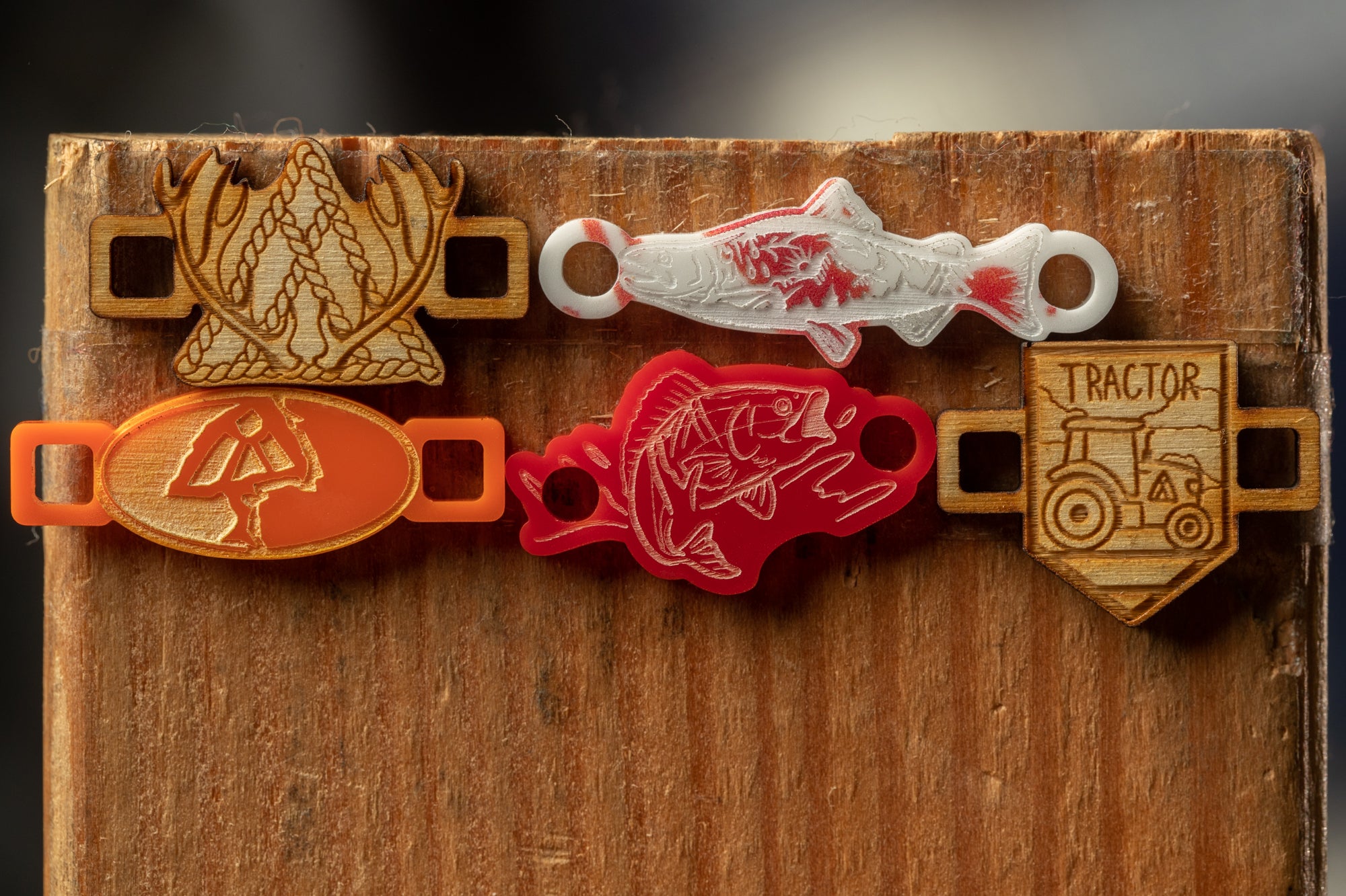 a wooden surface with various colorful and unique objects attached to it, including a lobster, a fish, a tractor, and a bird.