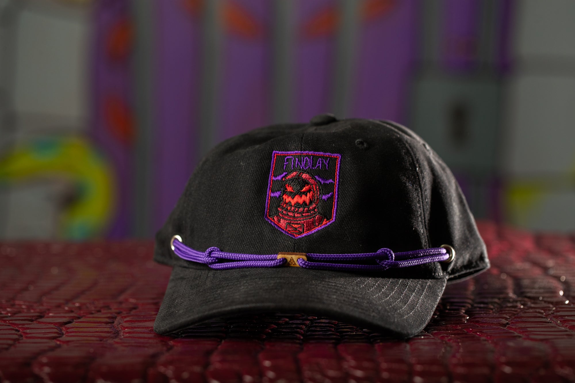 a black hat with a purple patch on it