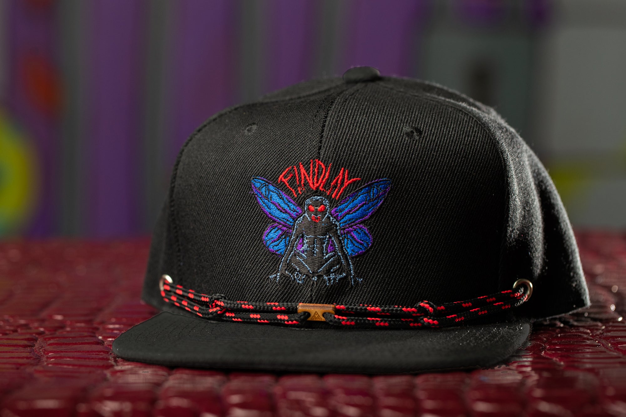 a black hat with a picture of a bee on it