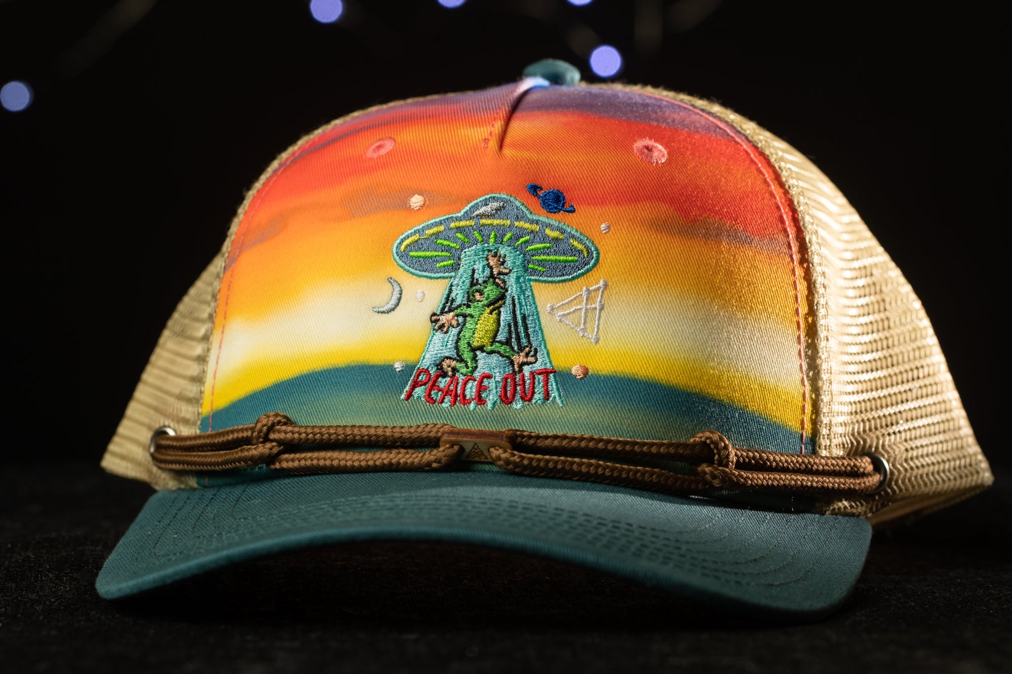 A colorful baseball cap with a peace sign and an alien-like creature on the front.
