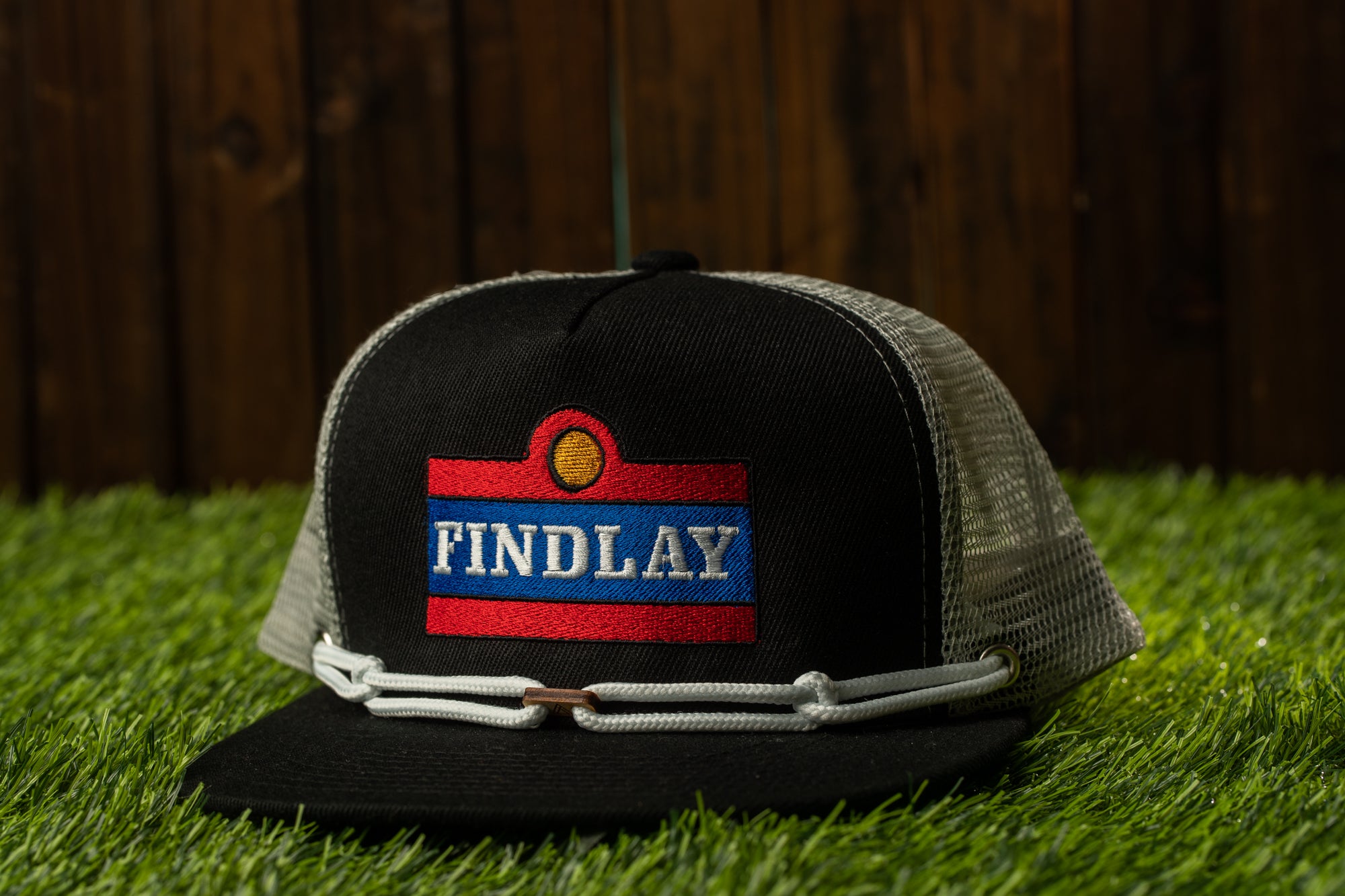 A black baseball cap with a red and blue patch on the front, displaying the word "FINDLAY" in white letters.