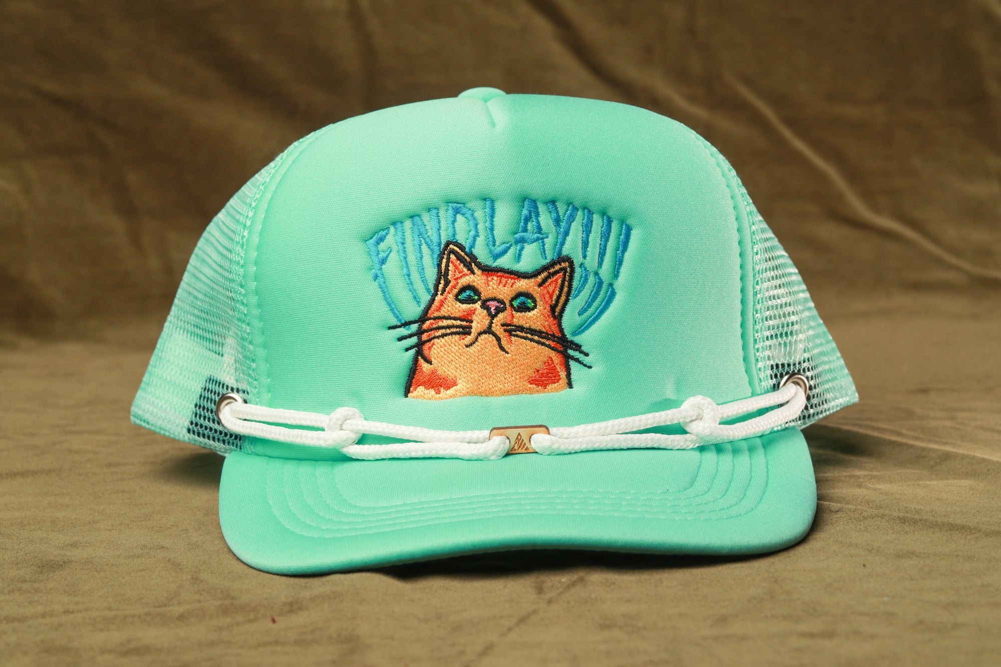 A turquoise baseball cap with a cat embroidered on it, featuring the text "FIND LAYY!"