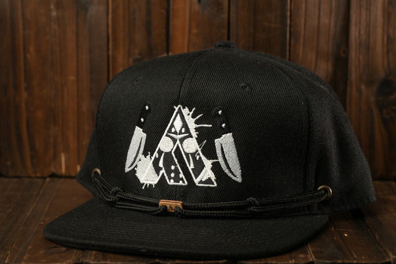 A black baseball cap with a white embroidered design on the front, featuring a skull and crossbones symbol.