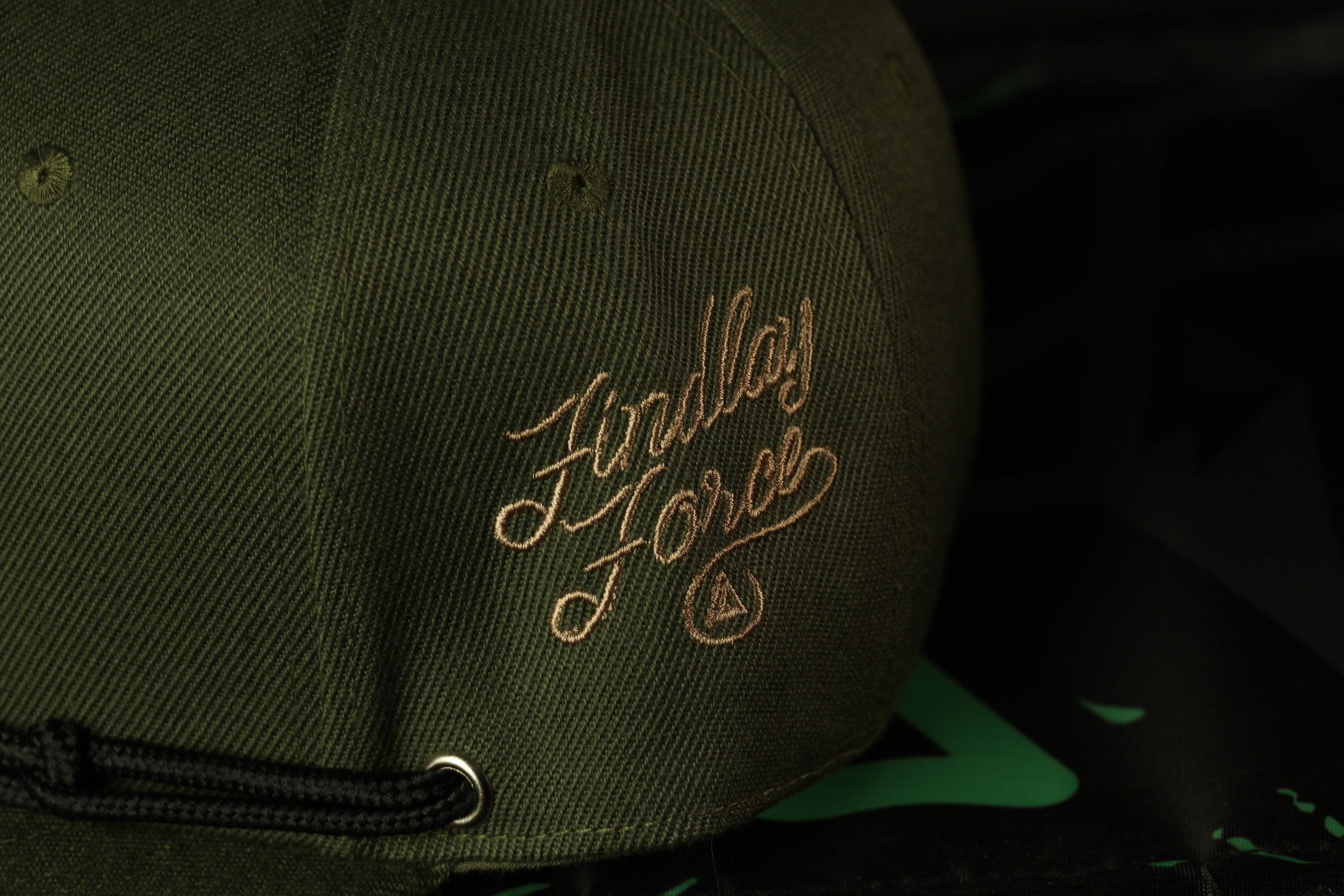 A close-up view of a green baseball cap with the embroidered text "First Order" on the side.