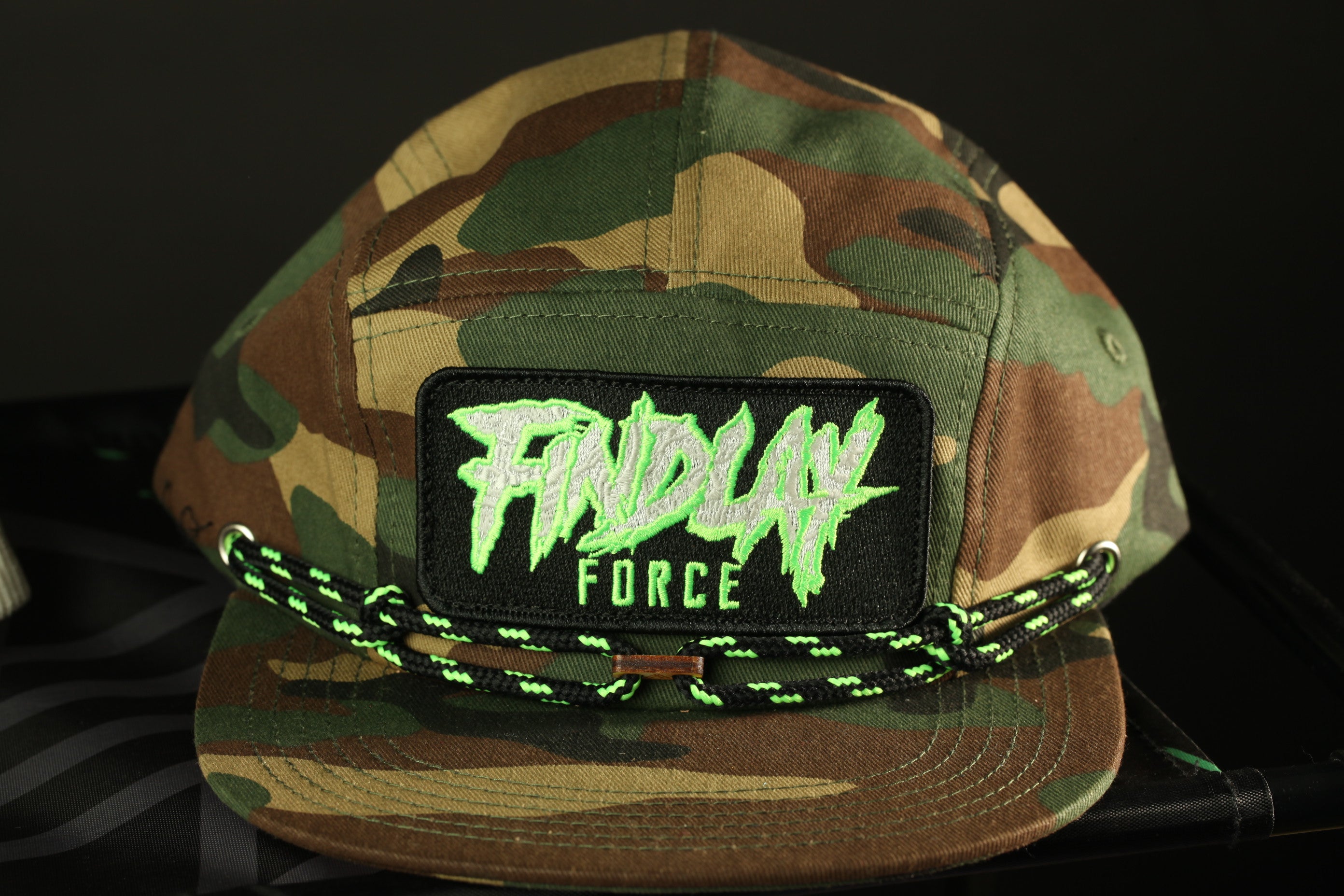 A camouflage baseball cap with a patch that says "FINDLAY FORCE".