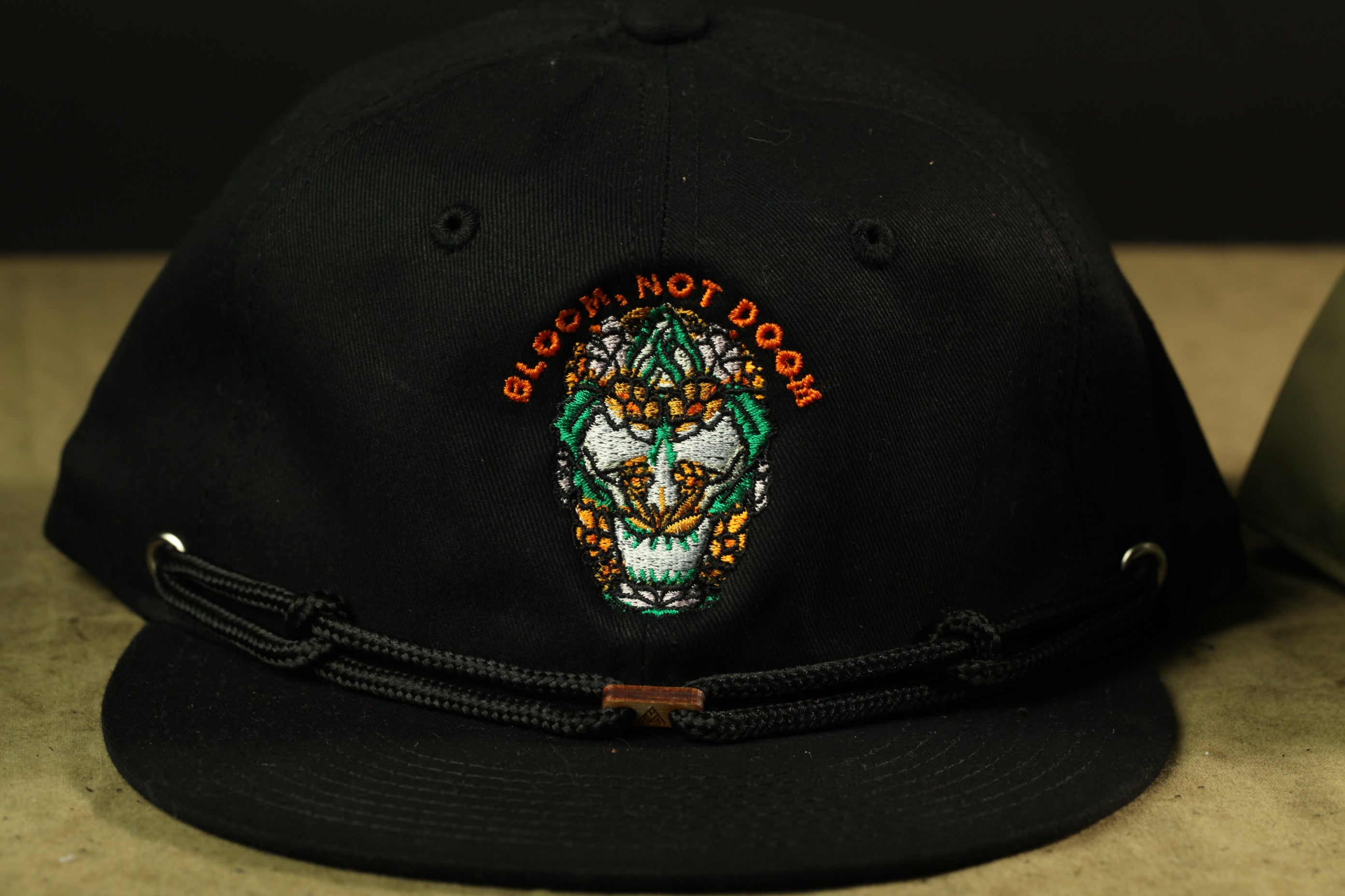 A black baseball cap with an embroidered design on the front.